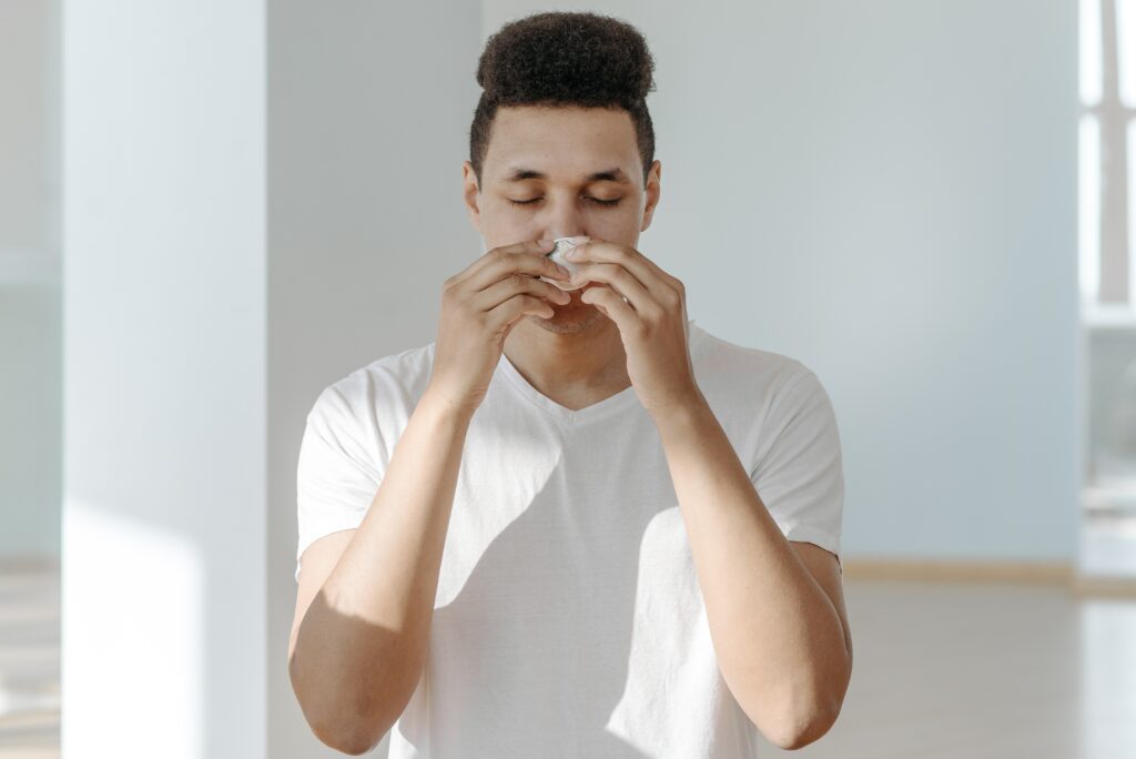 A man blowing his nose. Medical cannabis can support those dealing with hay fever thanks to its anti-inflammatory properties.