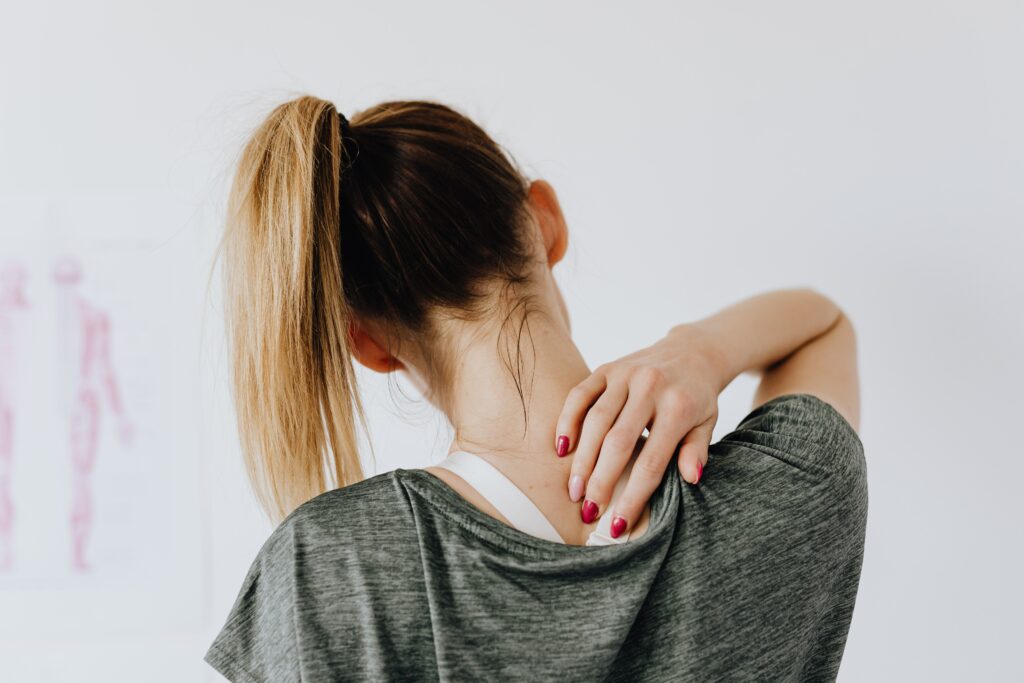 A woman holding her neck. Medical cannabis can support the millions of Brits that are living with chronic pain.