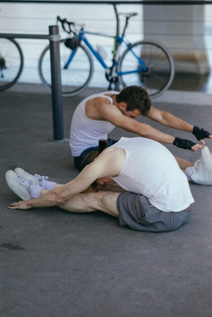 Two people doing stretches on the ground