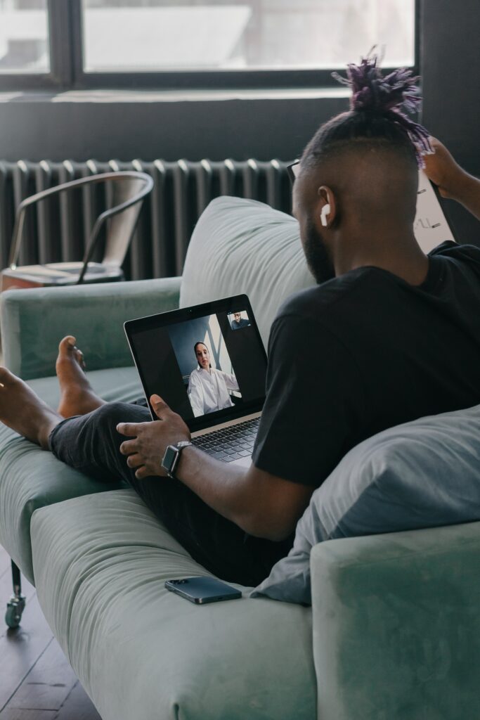 A man on his sofa in a video consultation with his doctor