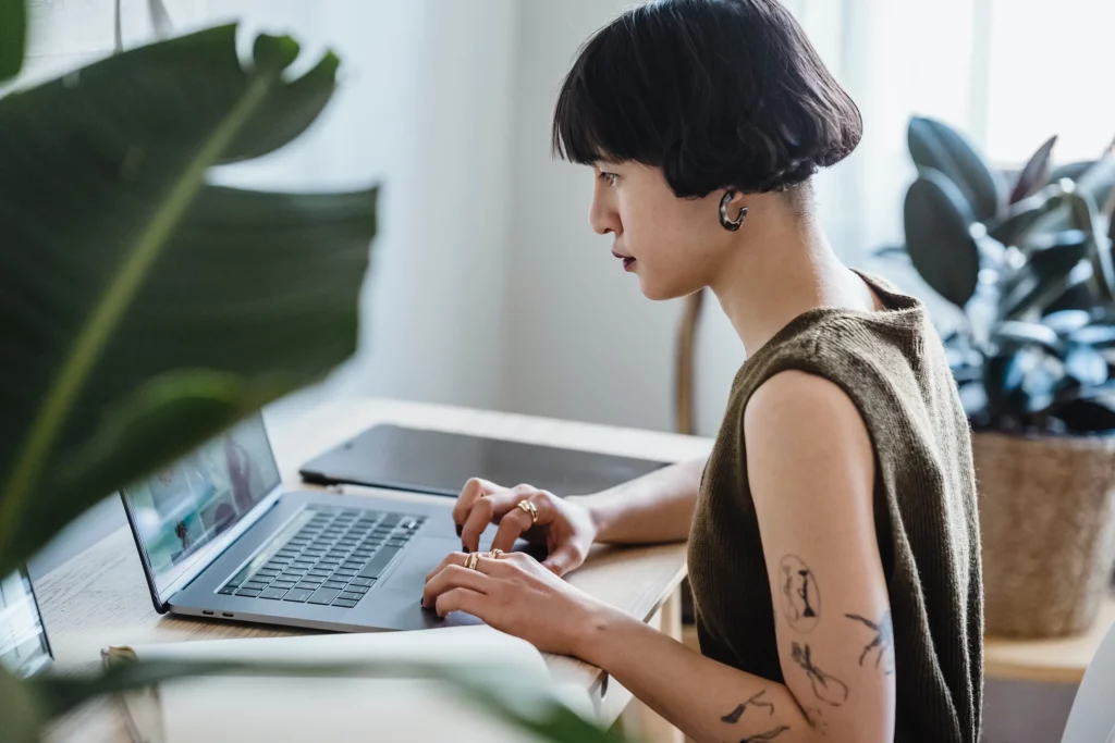 A woman sat at her desk using her laptop