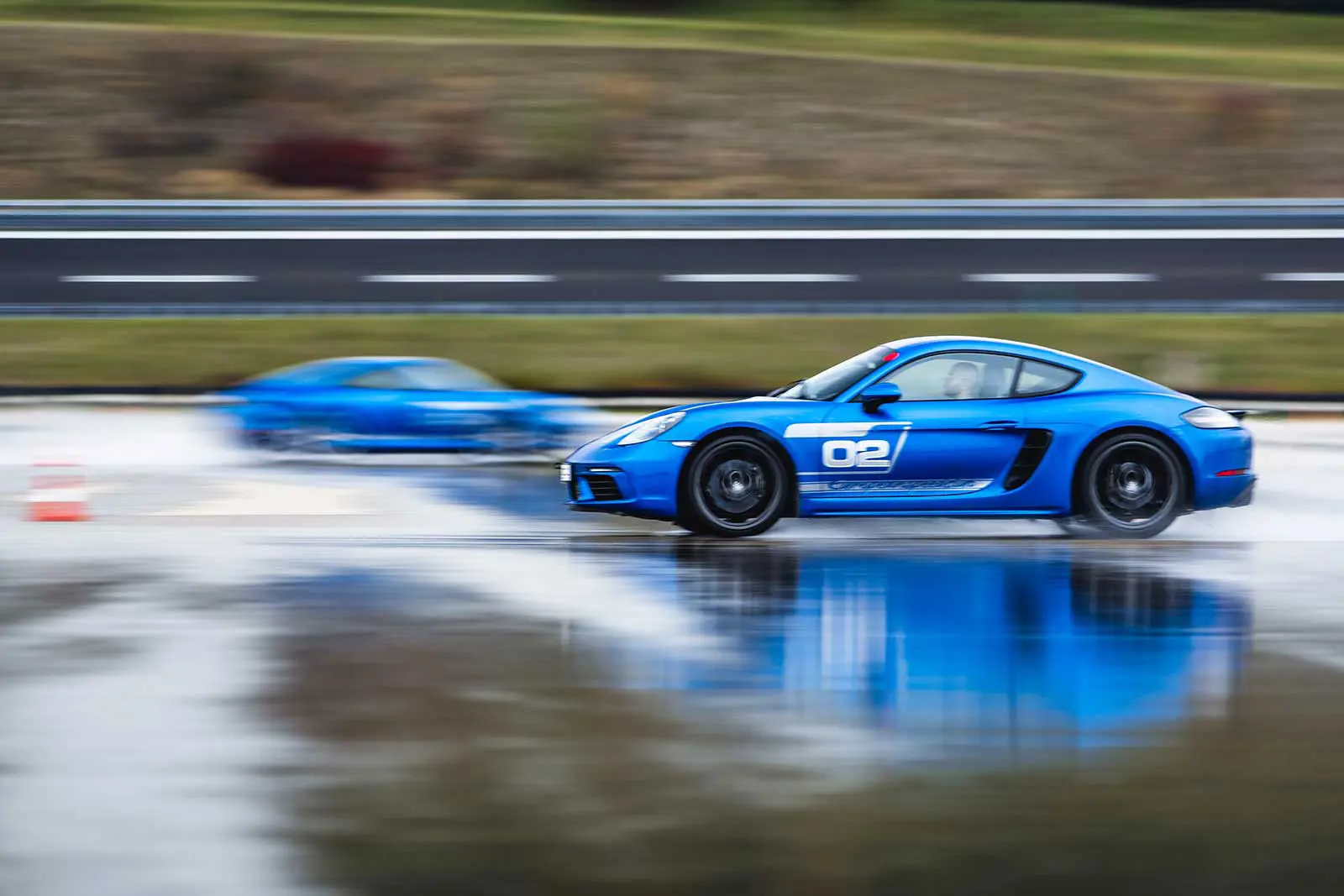 CarForGo Konzept – Zwei blaue Porsche 718 Cayman auf der Boxberg Dynamikfläche bei Nässe für Trackday       ohne eigenes Auto
