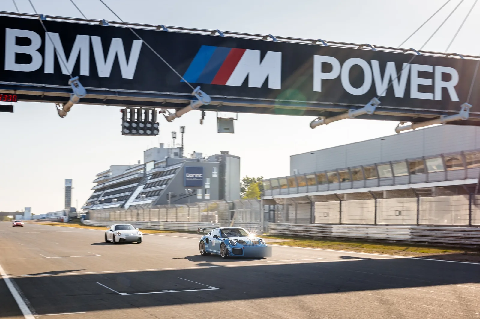 Porsche 911 on the almost empty Nürburgring Grand Prix straight under the BMW M Power bridge at the ESC track day