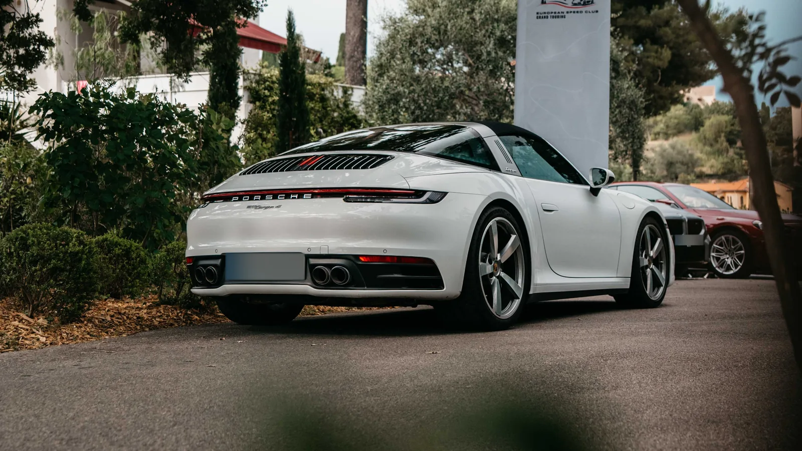 Weißer Porsche 911 Targa 4 mit ESC-Grand-Touring-Banner an der Côte d’Azur zum Start der Reise Grand Le Mans