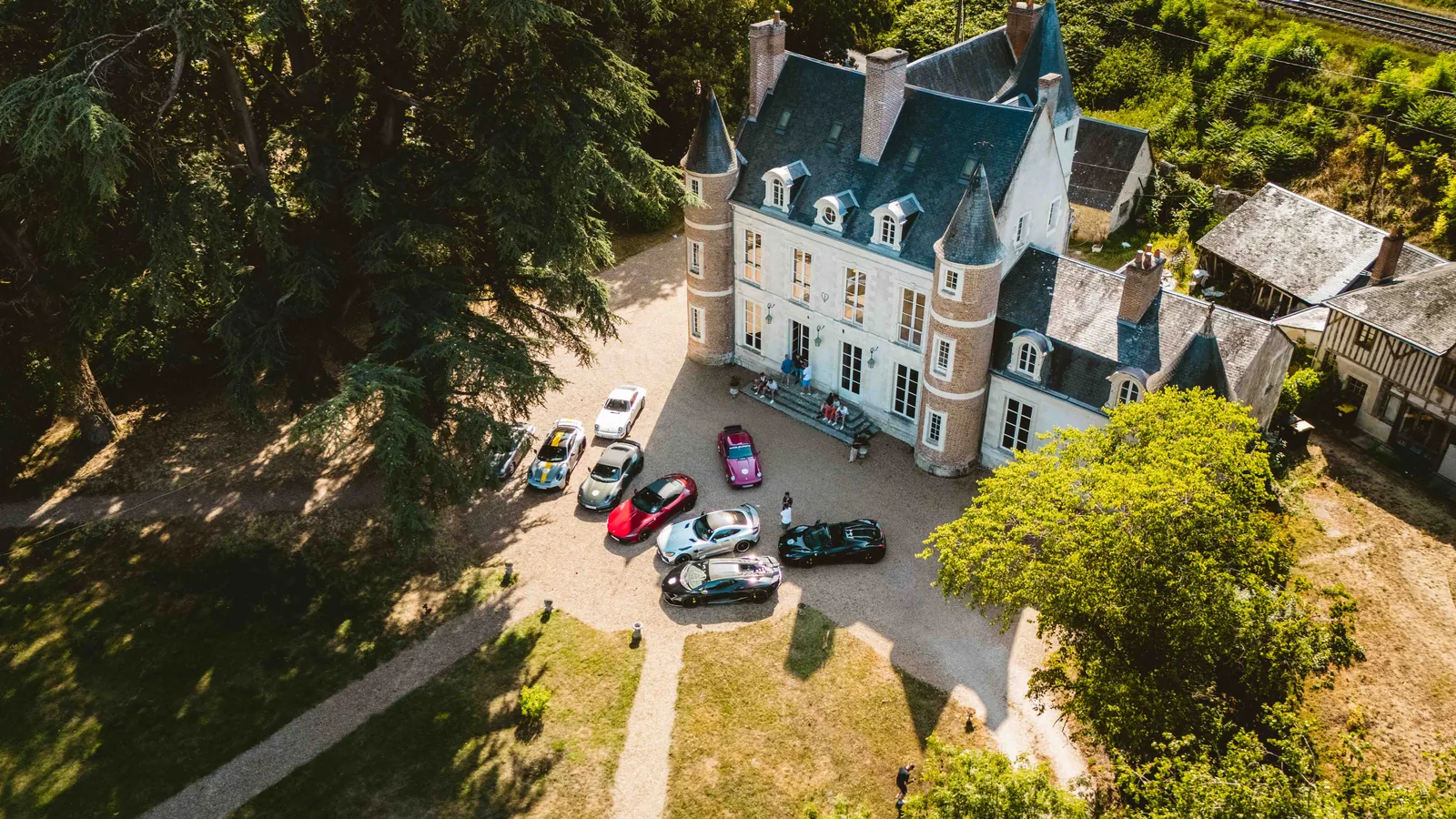 Château im Loire-Tal aus der Luft mit den Sportwagen der Grand-Le-Mans-Gruppe im Hof