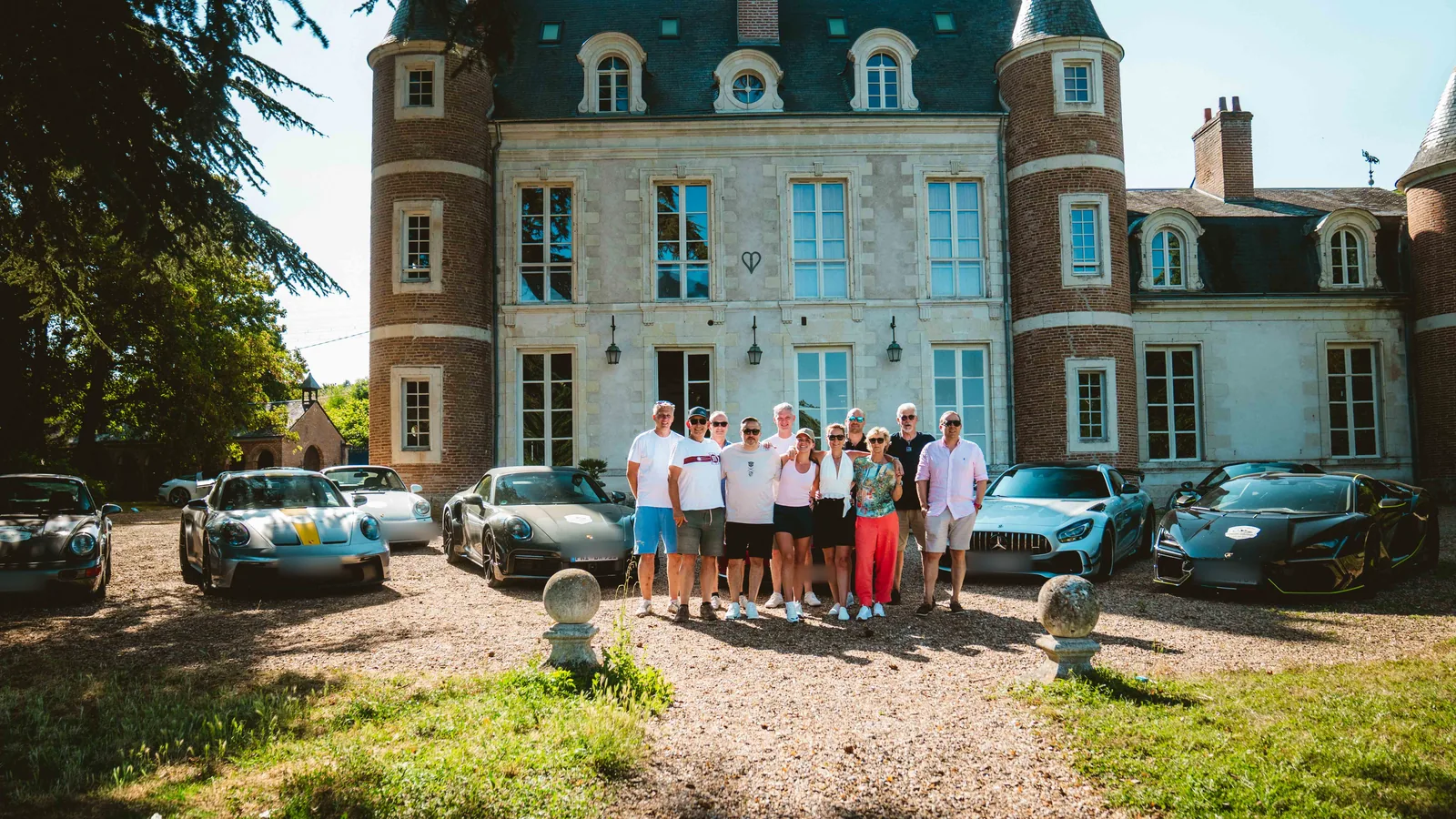 Teilnehmergruppe von Grand Le Mans mit ihren Sportwagen vor dem Château bei Tours