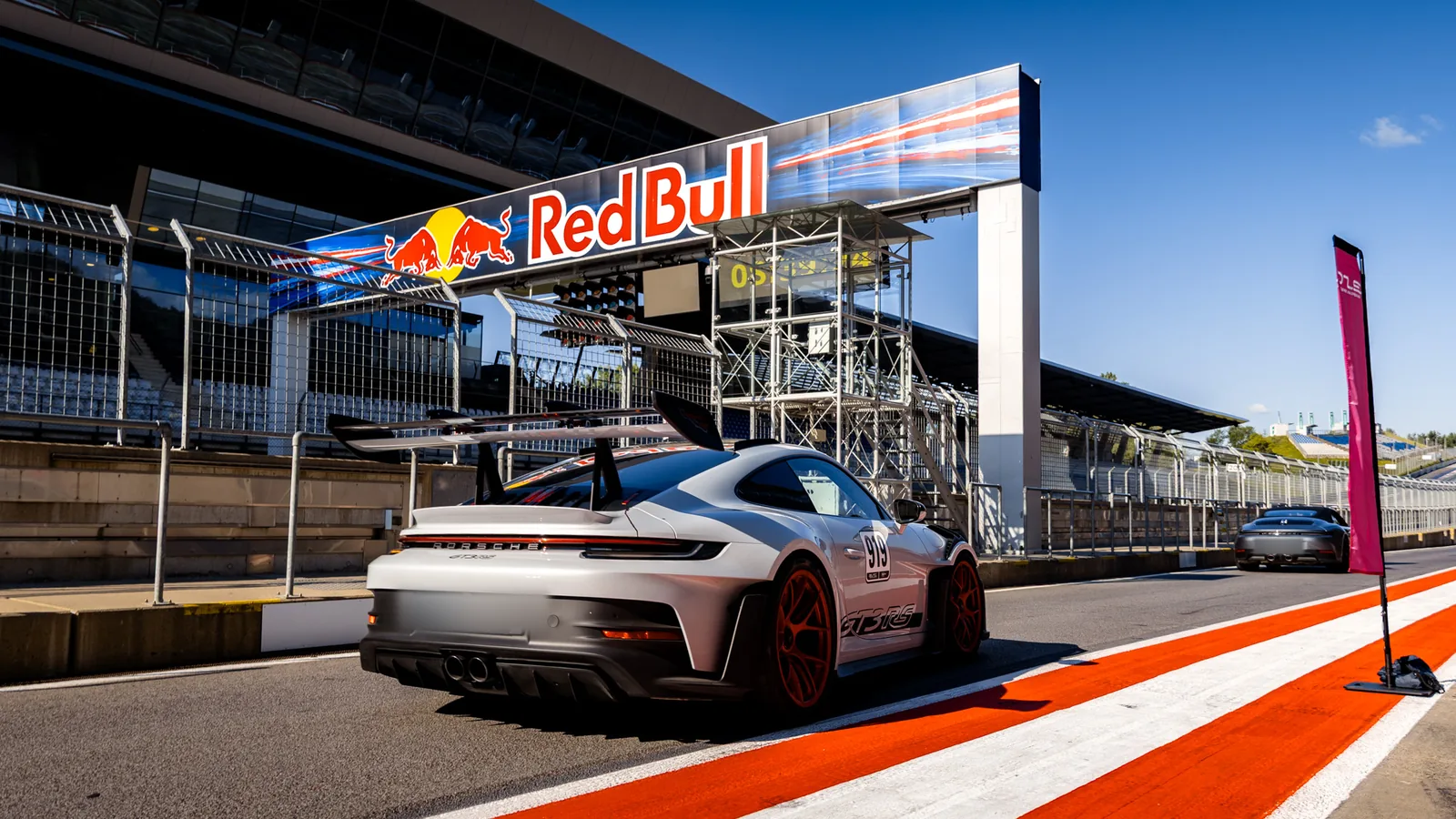Sportwagen in der Boxengasse am Red Bull Ring unter dem Streckenbogen