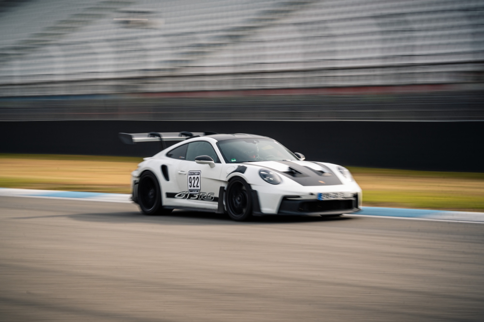 White Porsche 911 GT3 RS at high speed on the Hockenheimring during an ESC trackday — driving a race car yourself on a circuit