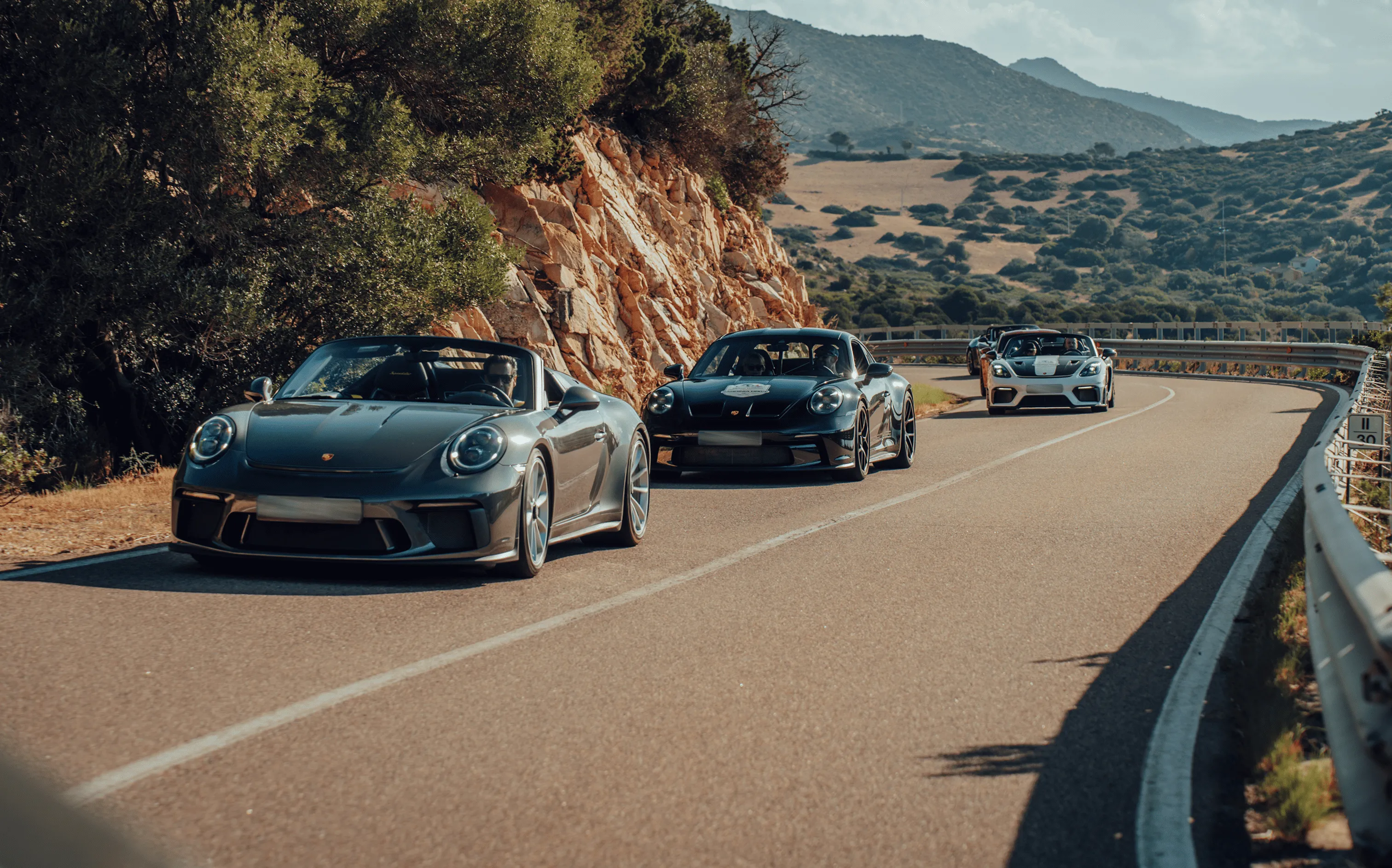 Sports car tour through the Alps – Porsche 911 GT3 on hairpin bends at sunrise