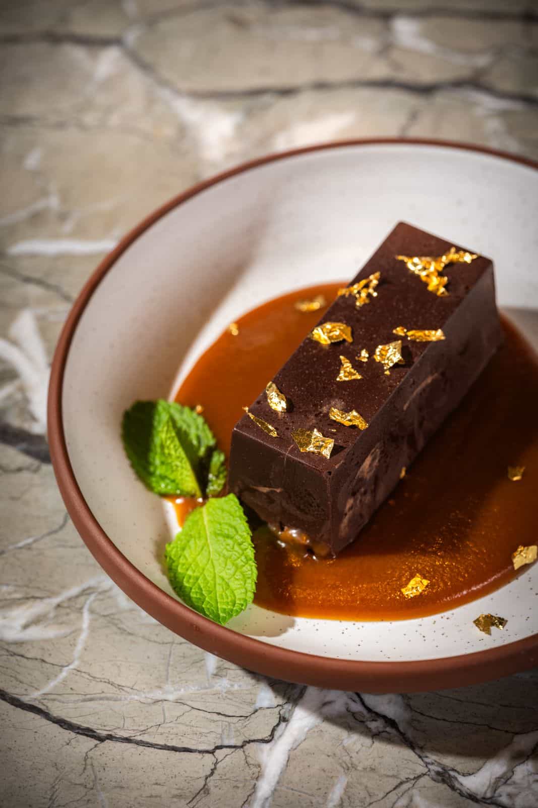 Cheese board with grapes, nuts, toast, quince jelly, and a variety of Spanish cheeses, served on a wooden stand