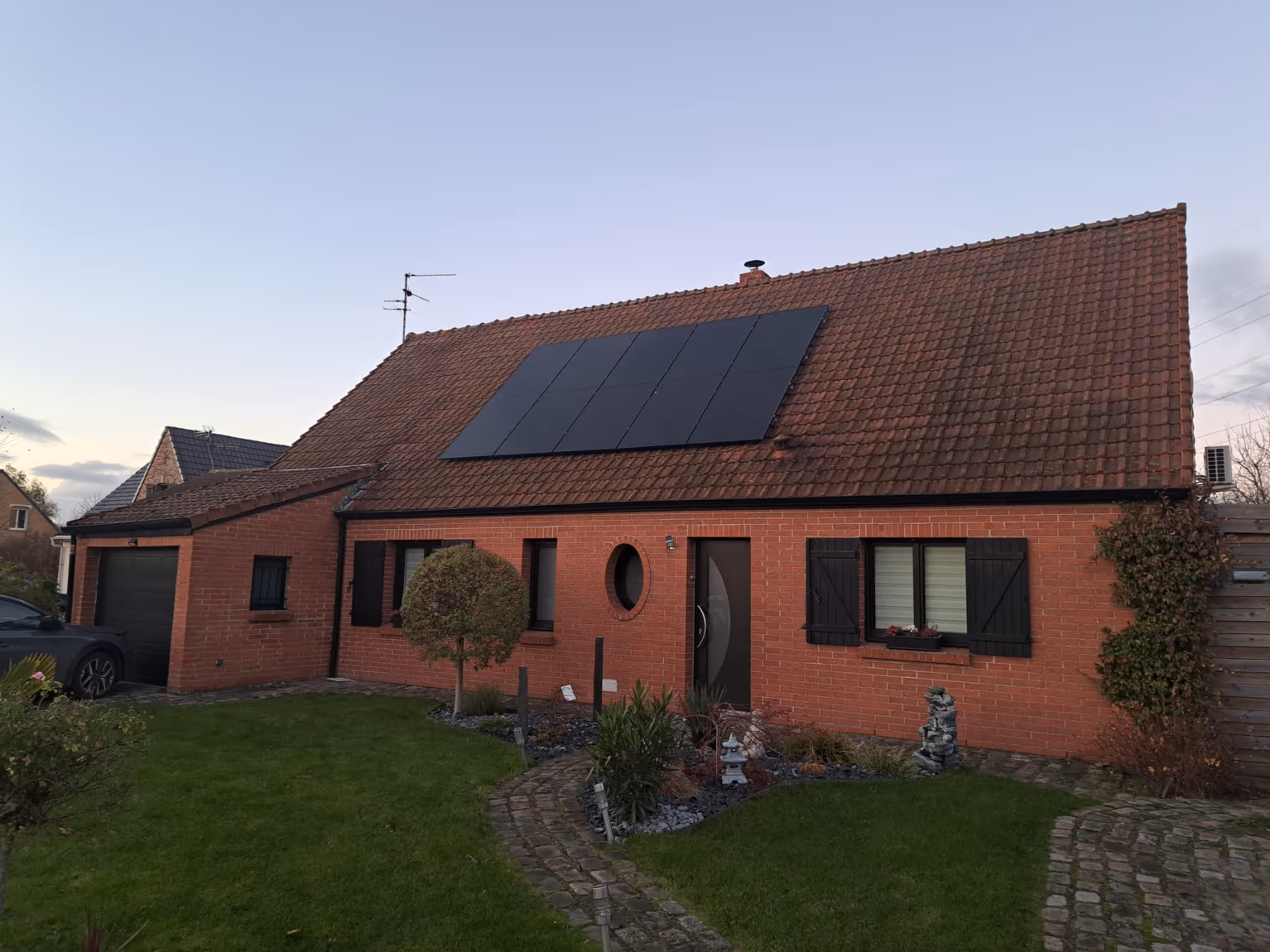 Maison rouge avec des panneaux solaires sur le toit