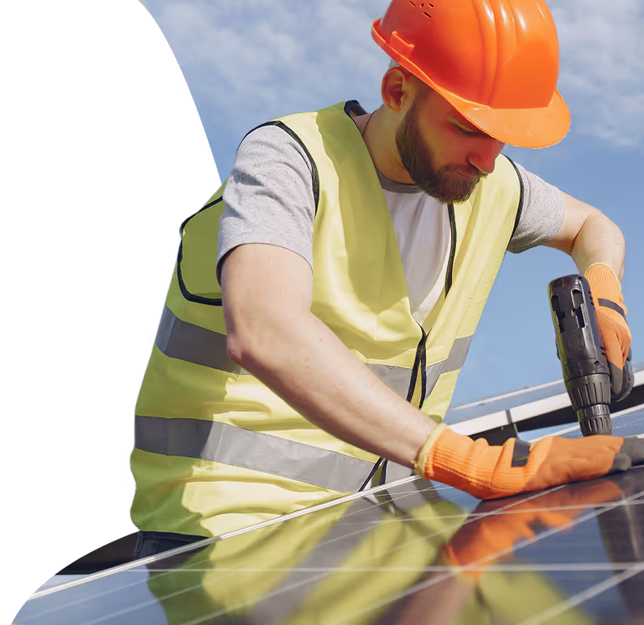 Un homme fixe des panneaux solaires sur le toit d'une maison Un homme fixe des panneaux solaires sur le toit d'une maison