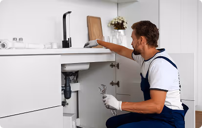 Plombier qui travail sur lavabo