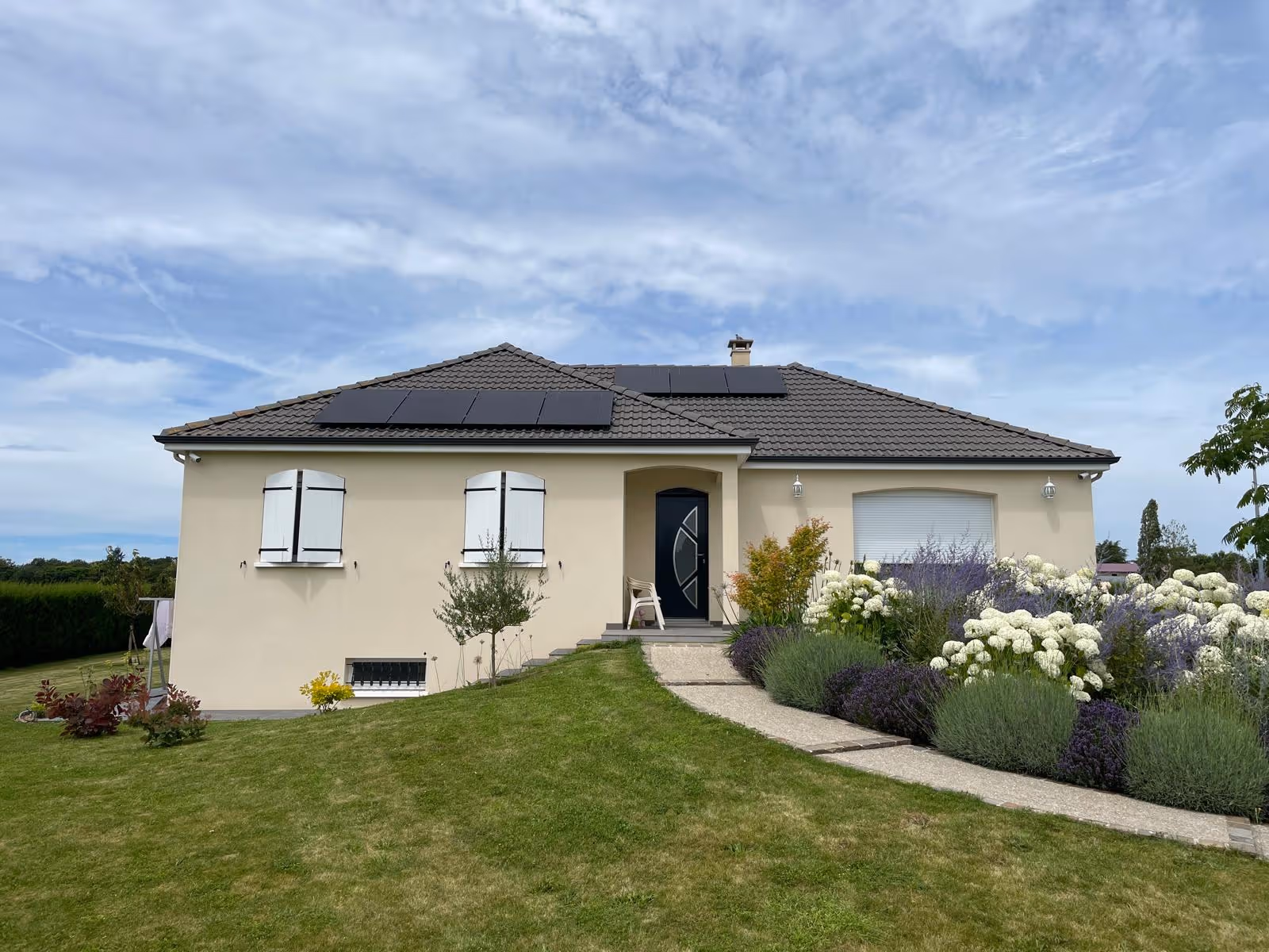 Une maison au bout d'un chemin avec des panneaux solaires