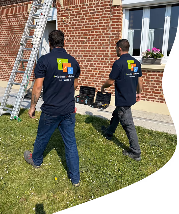 techniciens de dos entrain de marcher devant une maison en brique rouge