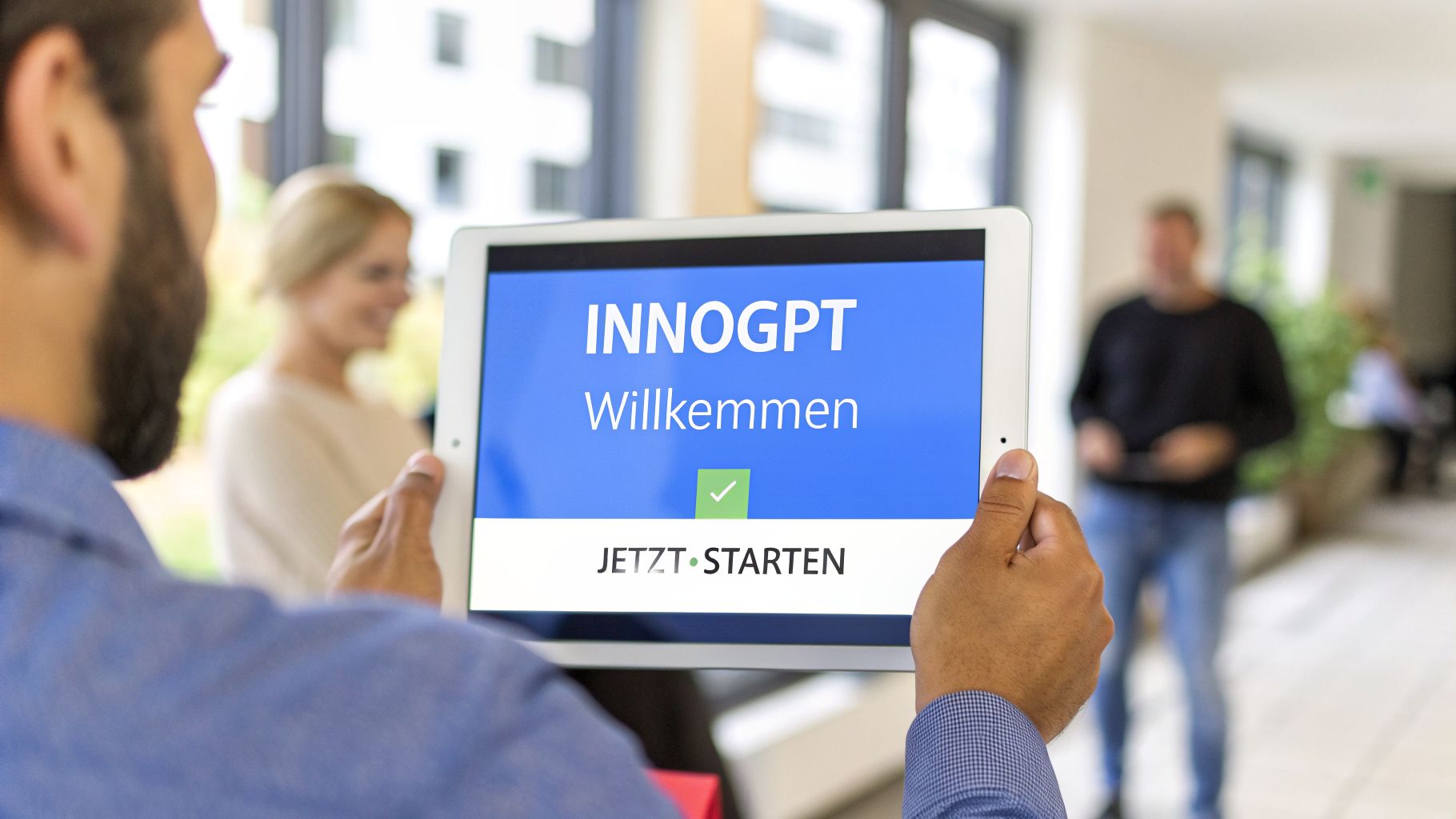 Mann hält Tablet mit "INNOGPT Willkommen" und "JETZT STARTEN" Text. im Hintergrund sind unscharfe Personen.