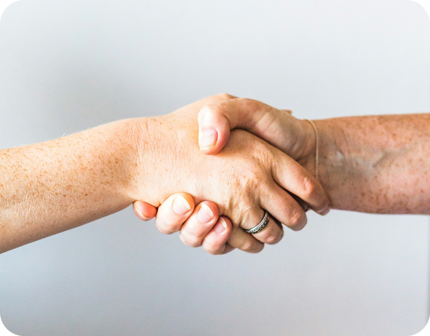 Duas mãos dadas criando um vínculo de acolhimento e transformação