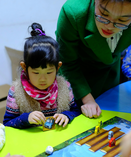 A Hollam private tutor woman and a little student playing a game.