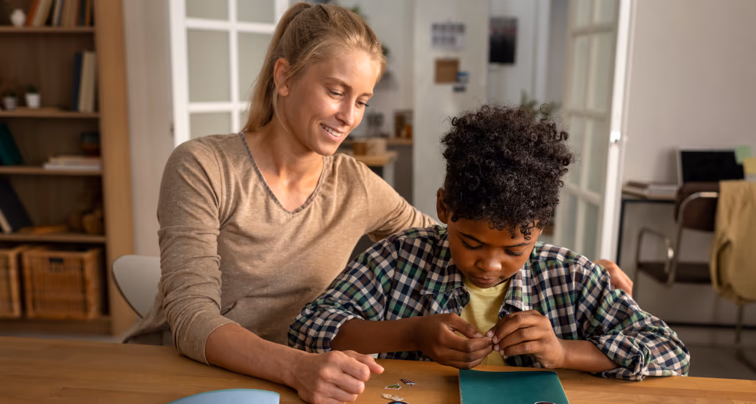A teacher and her student are sitting at a table.