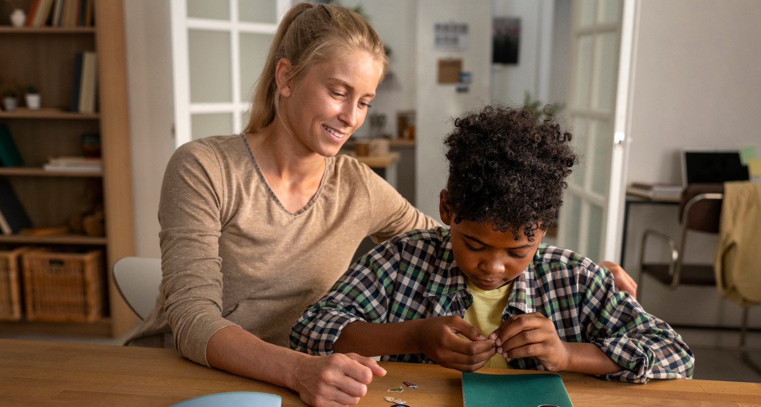 A teacher and her student are sitting at a table.
