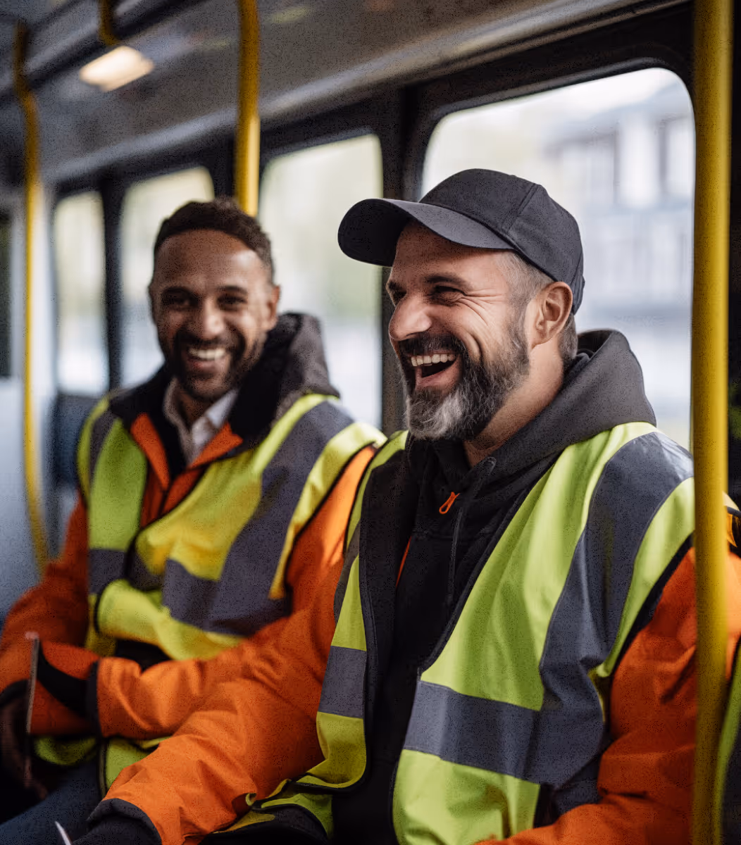 Two workers in high-visibility jackets on-board a Zeelo bus