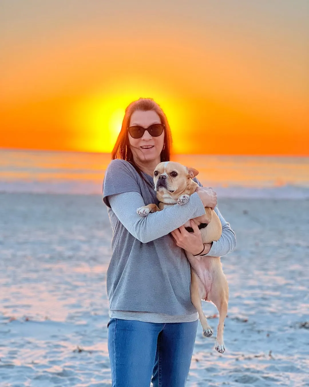 Royal Frenchel being held by its owner at the ocean during sunset.