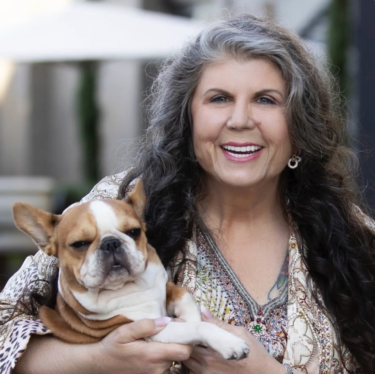 Anahata Graceland smiling while holding a Royal Frenchel dog.