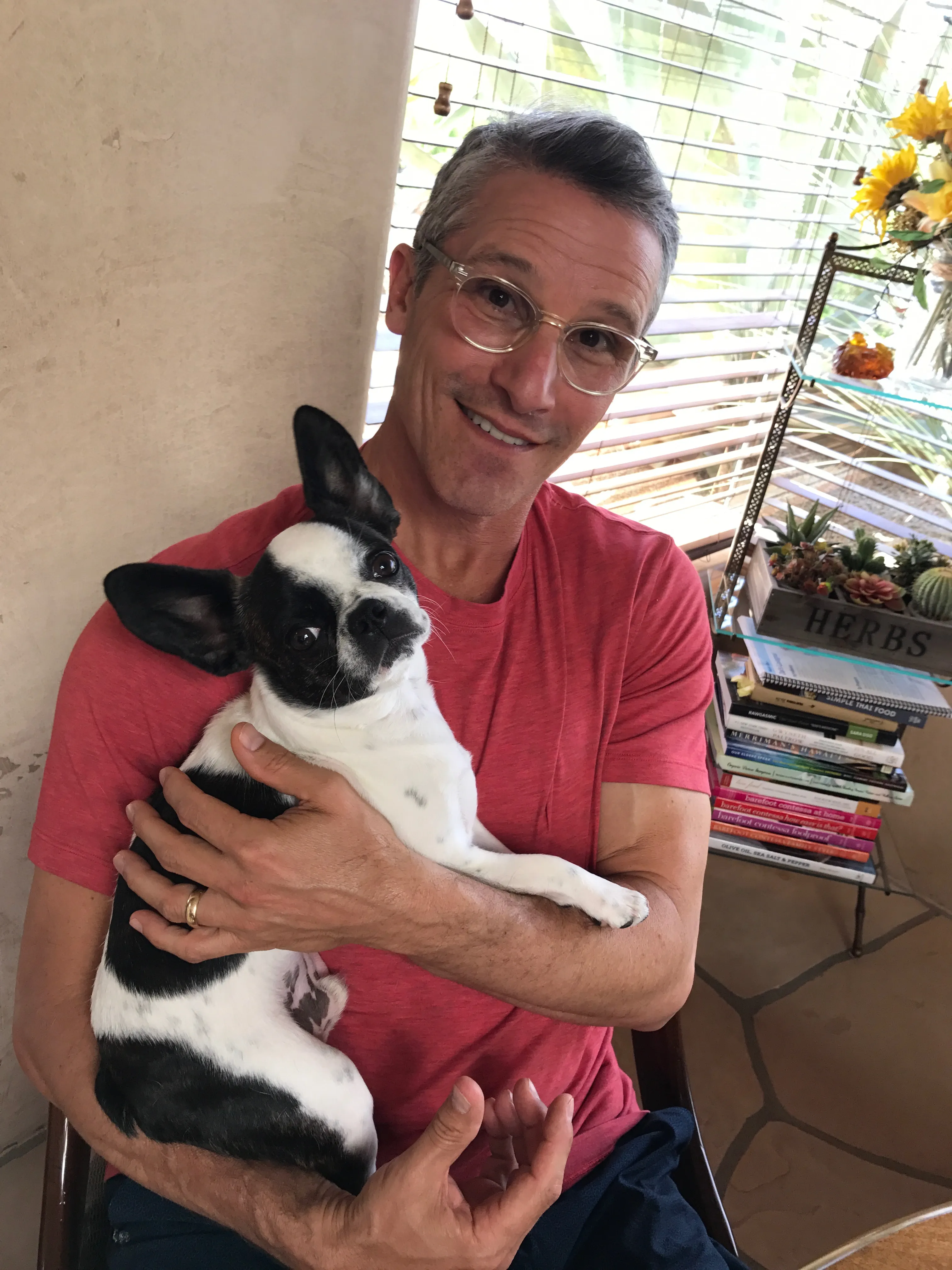 Micro Mini Royal Frenchel being held by a smiling owner in an apartment.