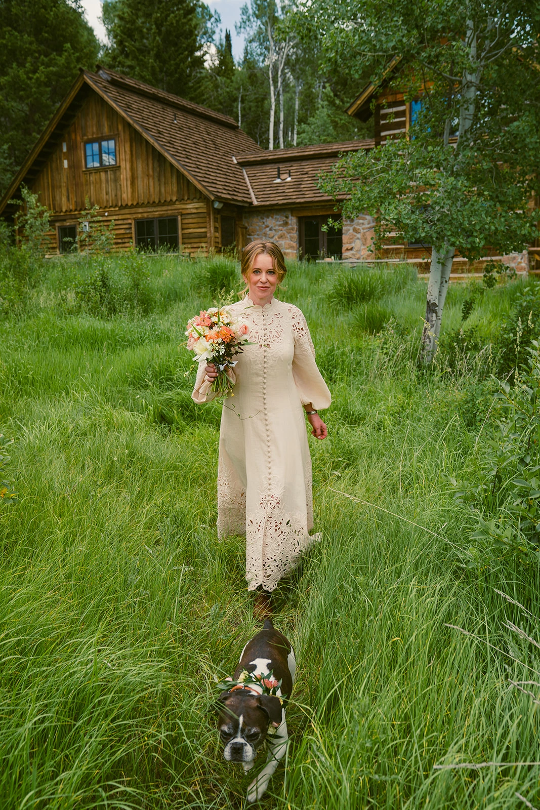 Girl in a formal dress posing with her Royal Frenchel wearing a flower collar.