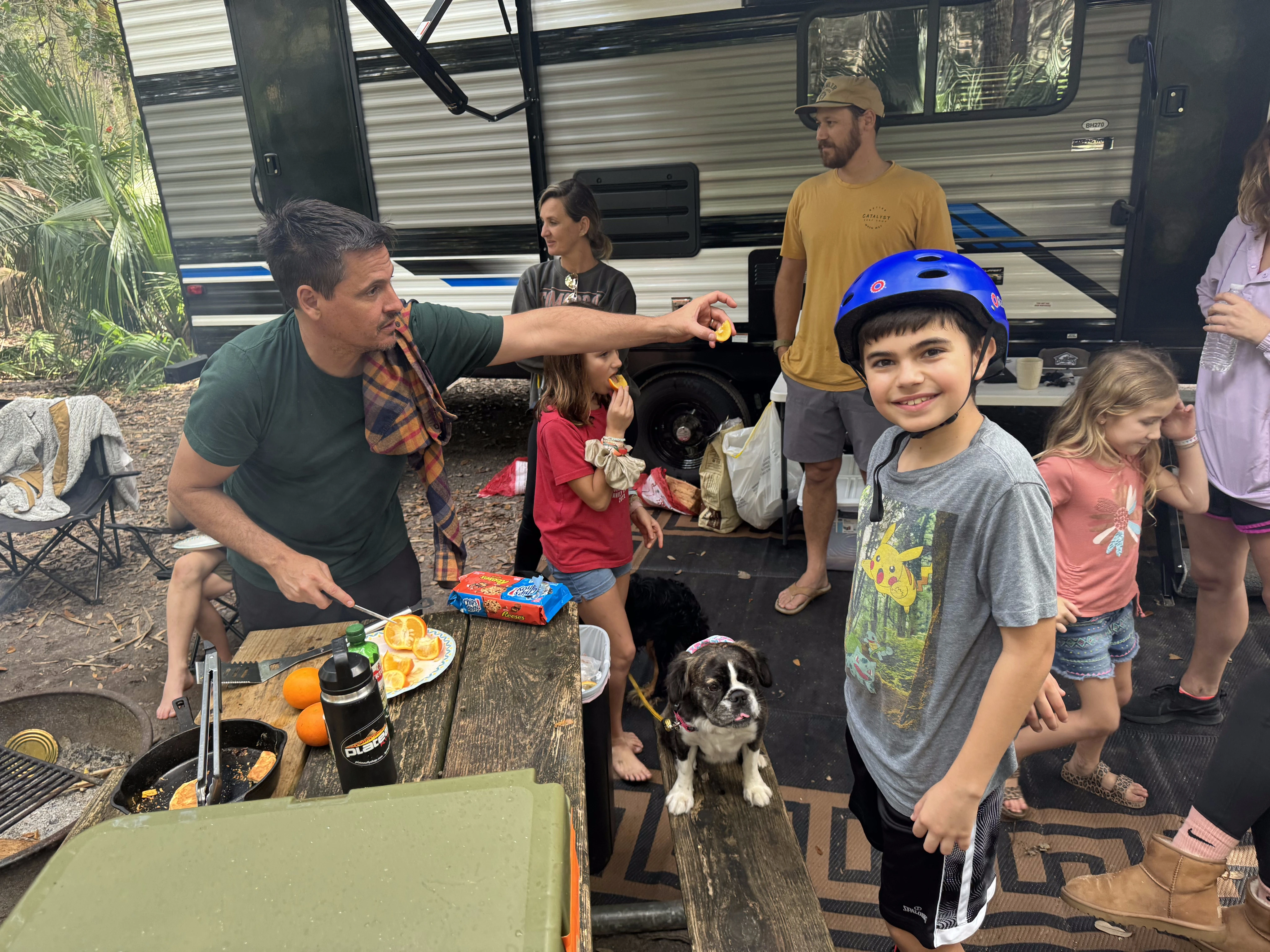 Royal Frenchel relaxing with a family during an RV camping trip.