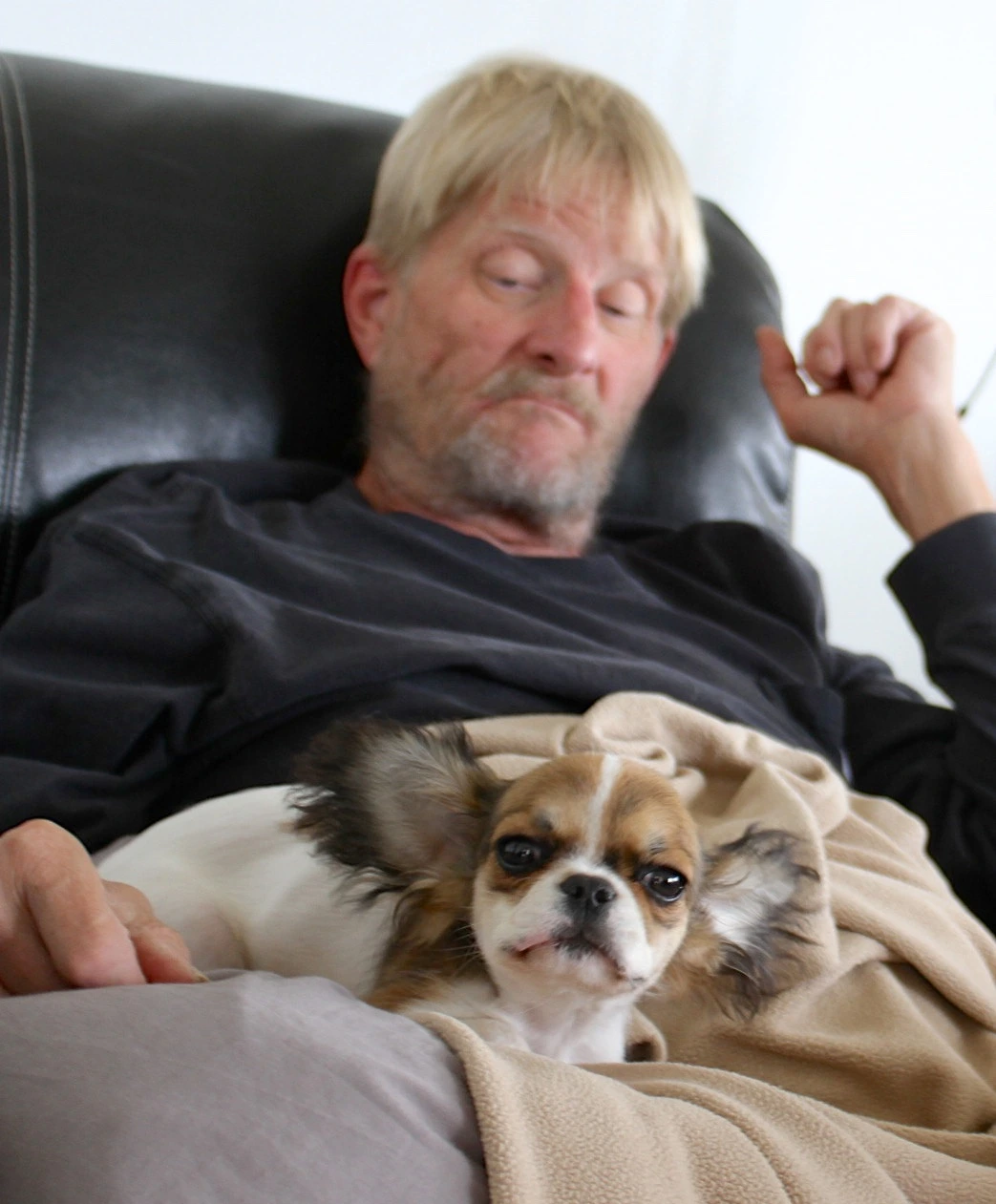 Man snuggling with his Royal Frenchel puppy.