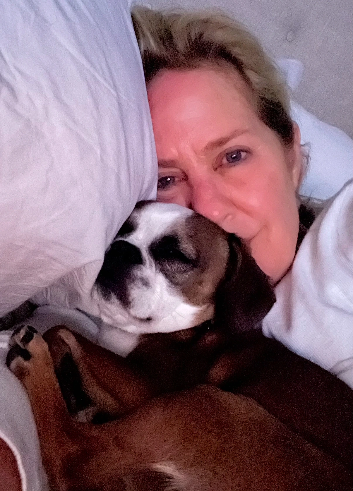 Woman snuggling with her Royal Frenchel in bed.
