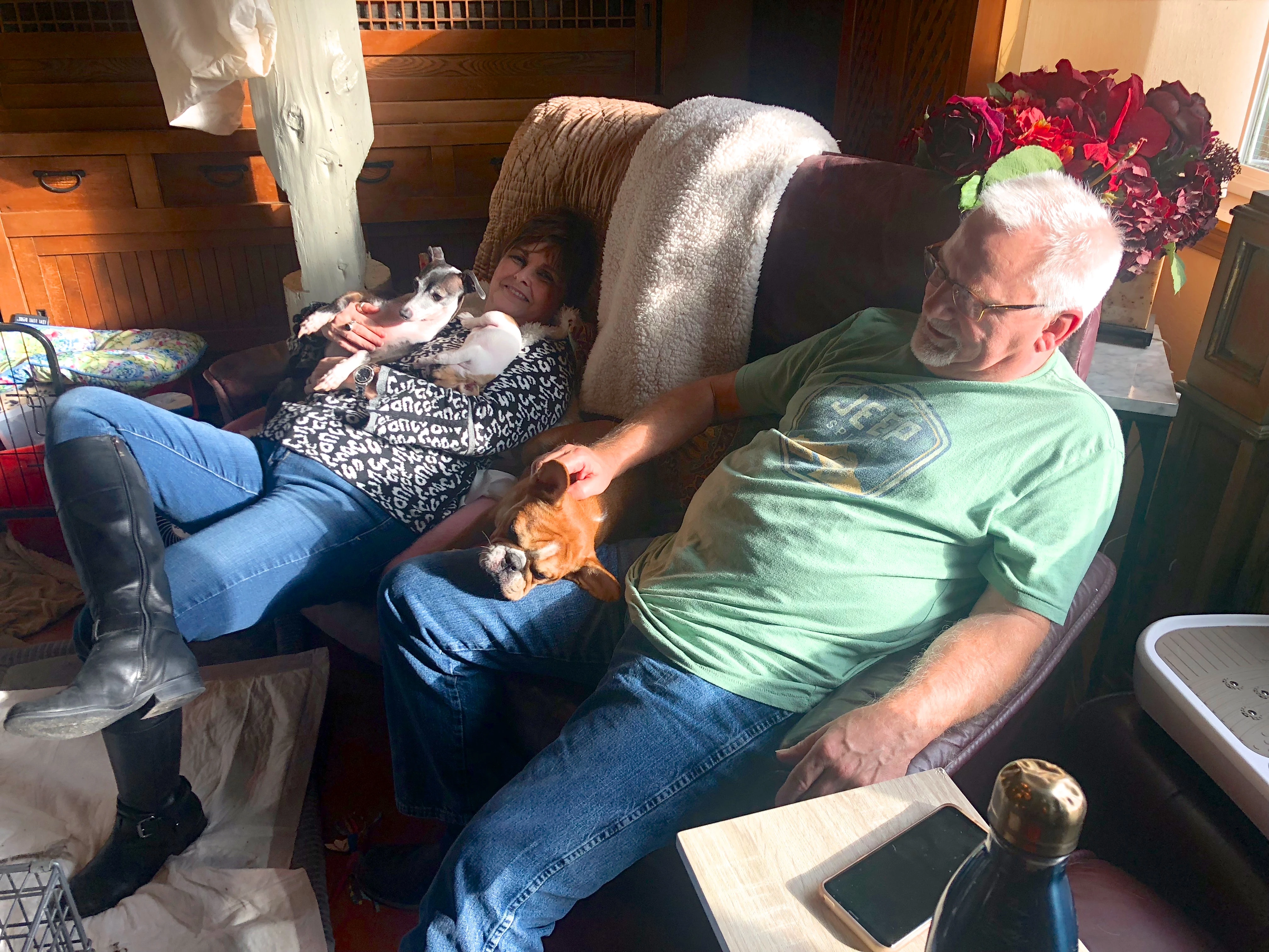 Senior couple sitting on a couch with three Royal Frenchels.