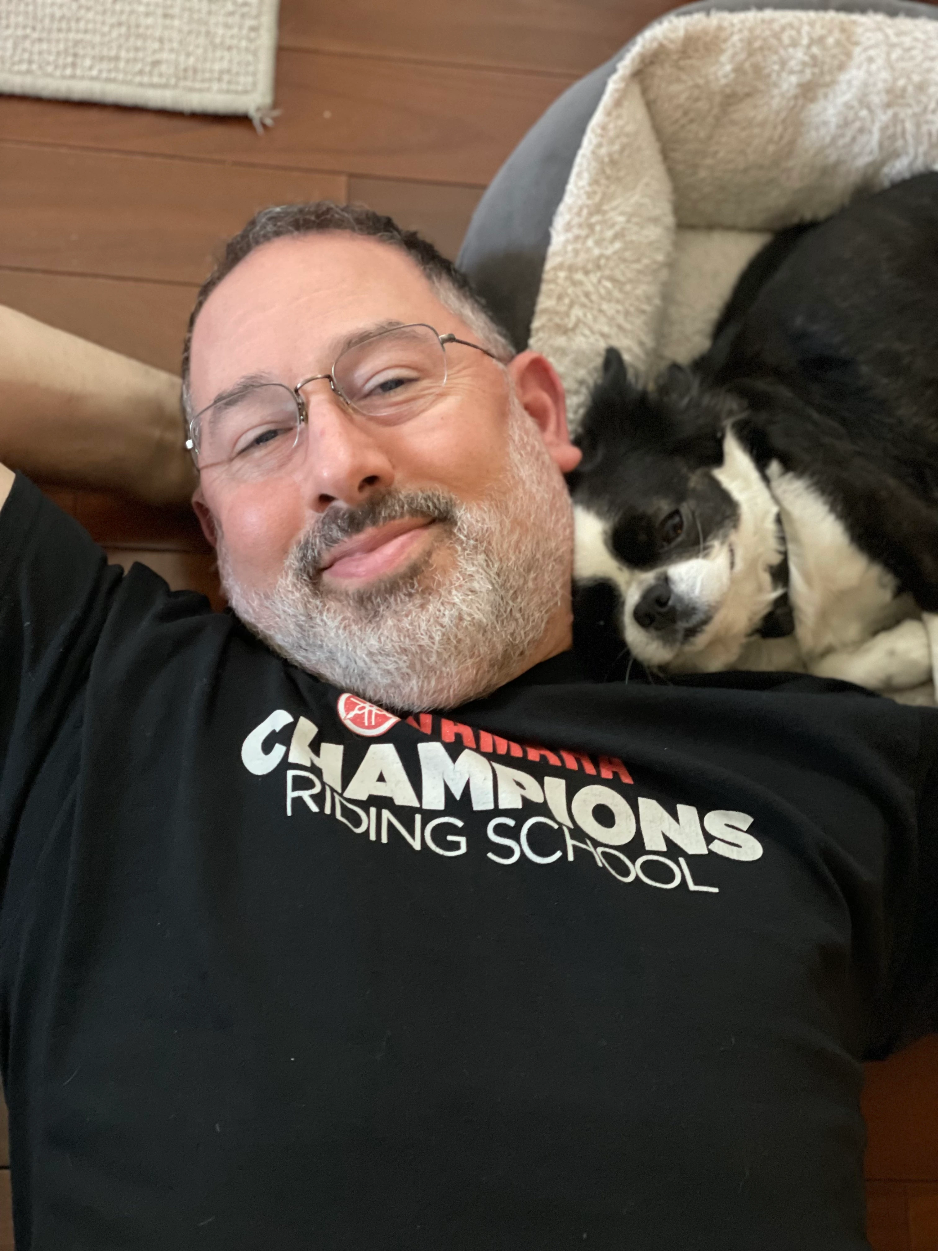 Man lying on the floor and cuddling with his Royal Frenchel.