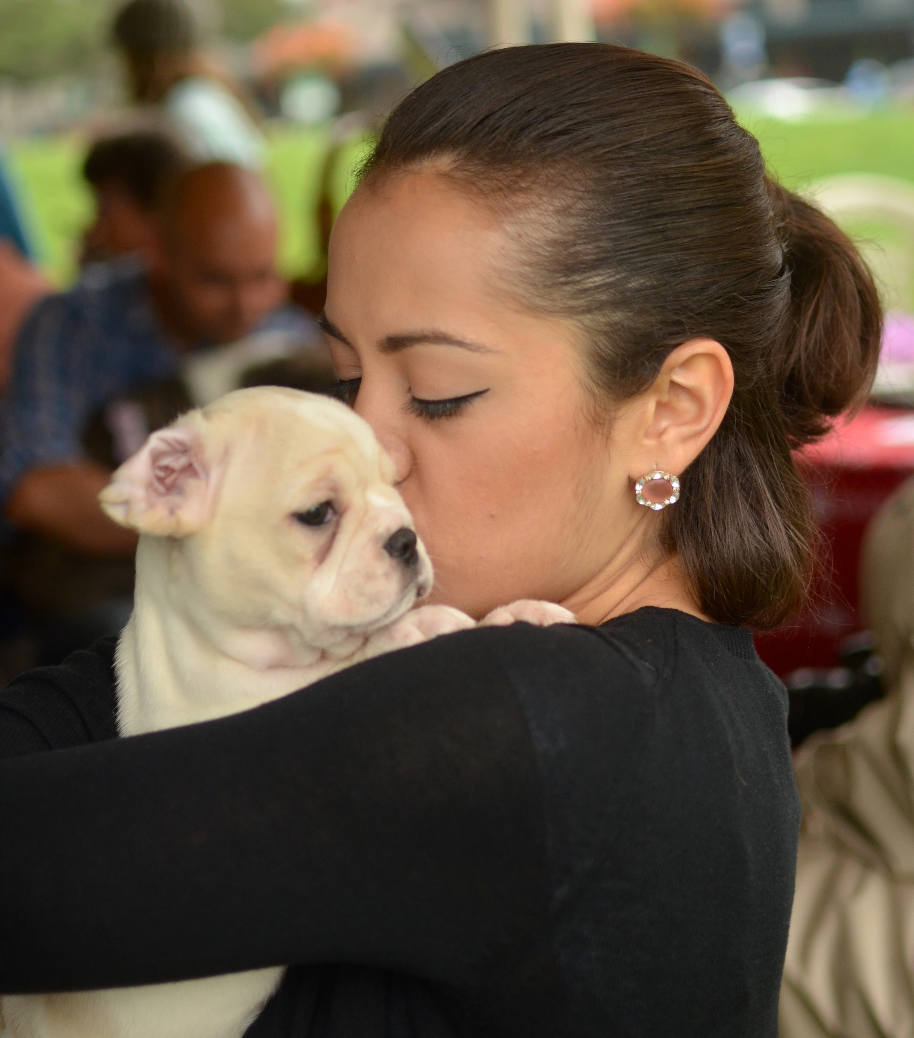 Woman hugging and kissing her Royal Frenchel puppy on the cheek.