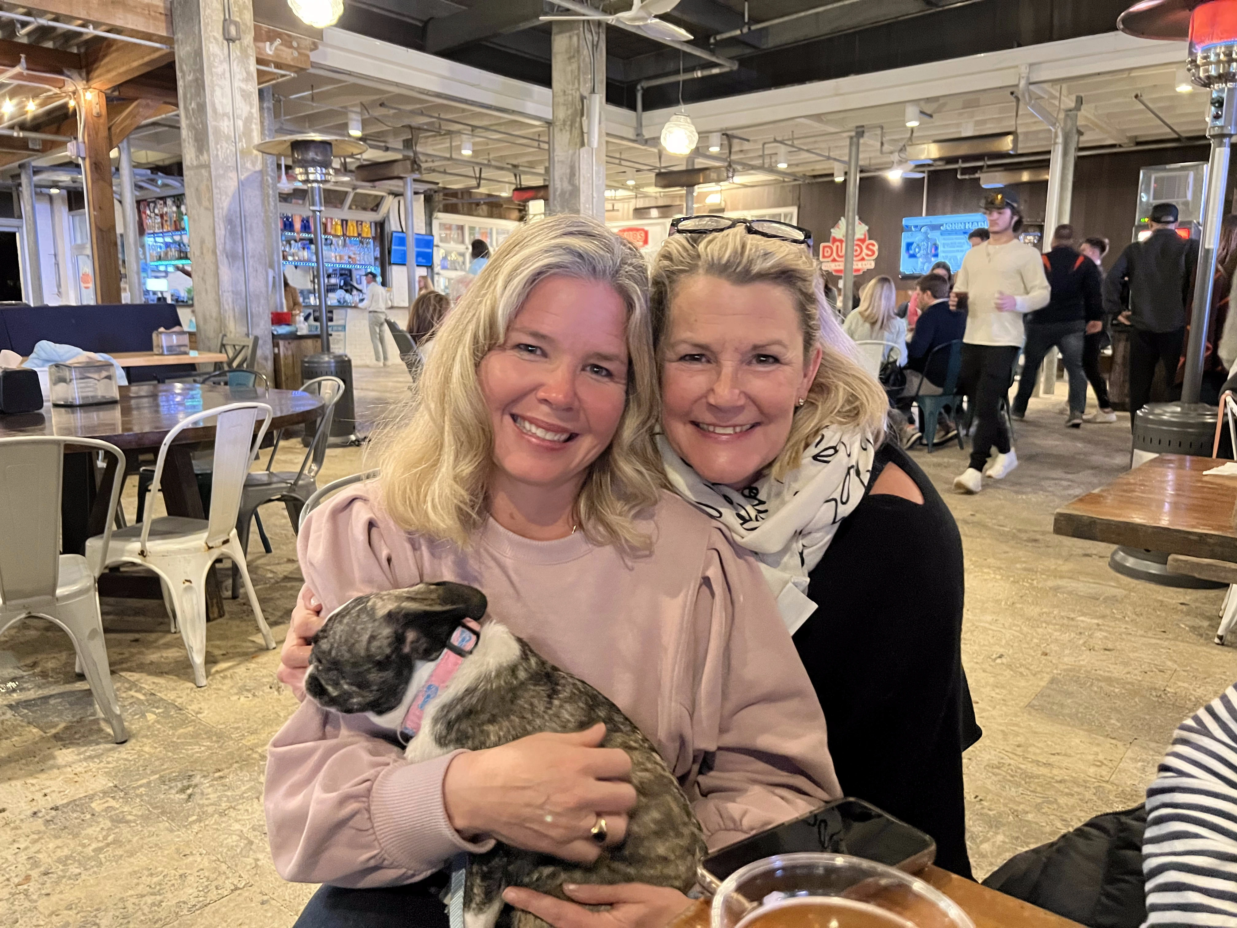 Two women together while one holds a Royal Frenchel in her arms.