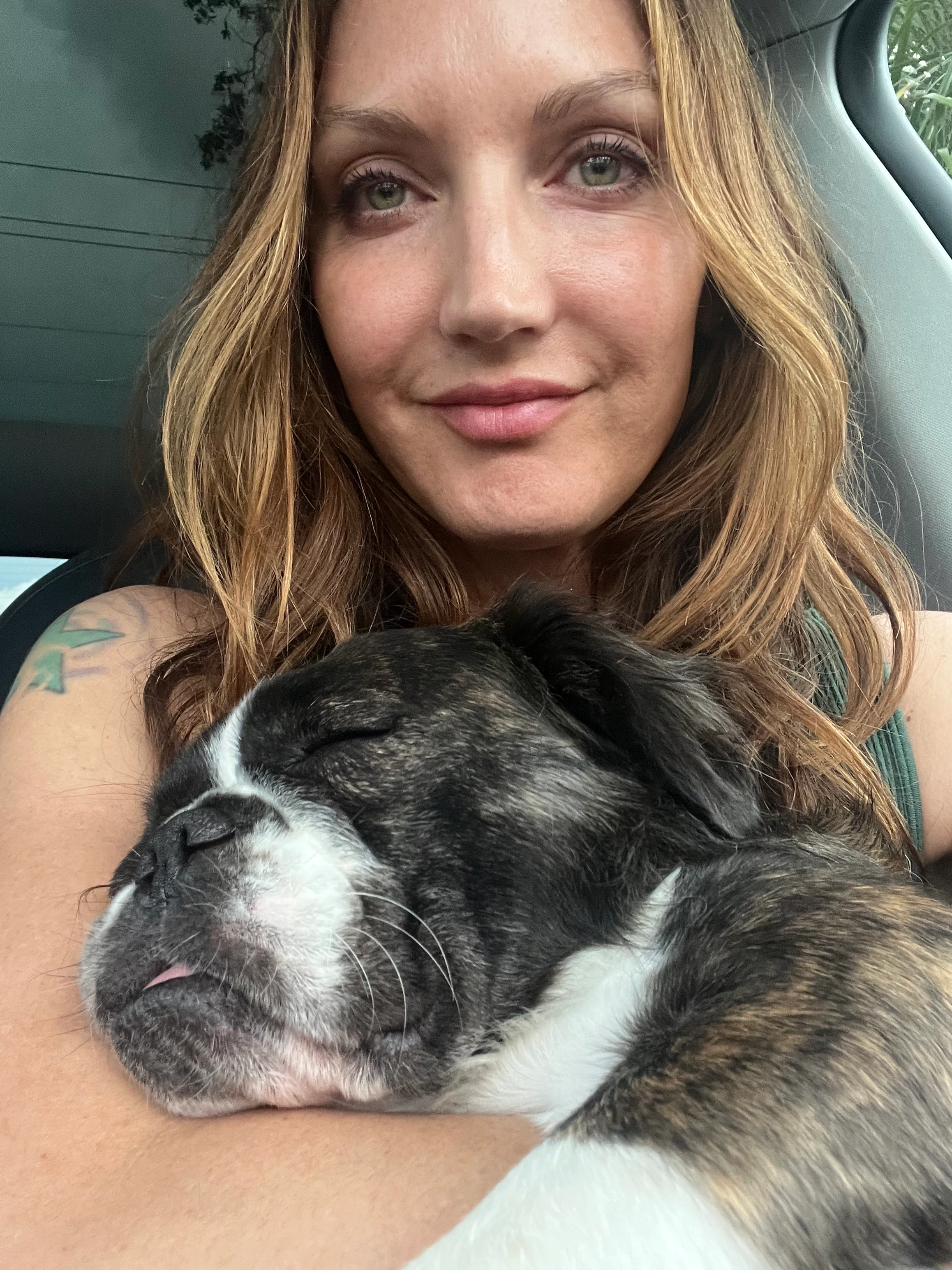 Woman holding and snuggling her sleeping Royal Frenchel.