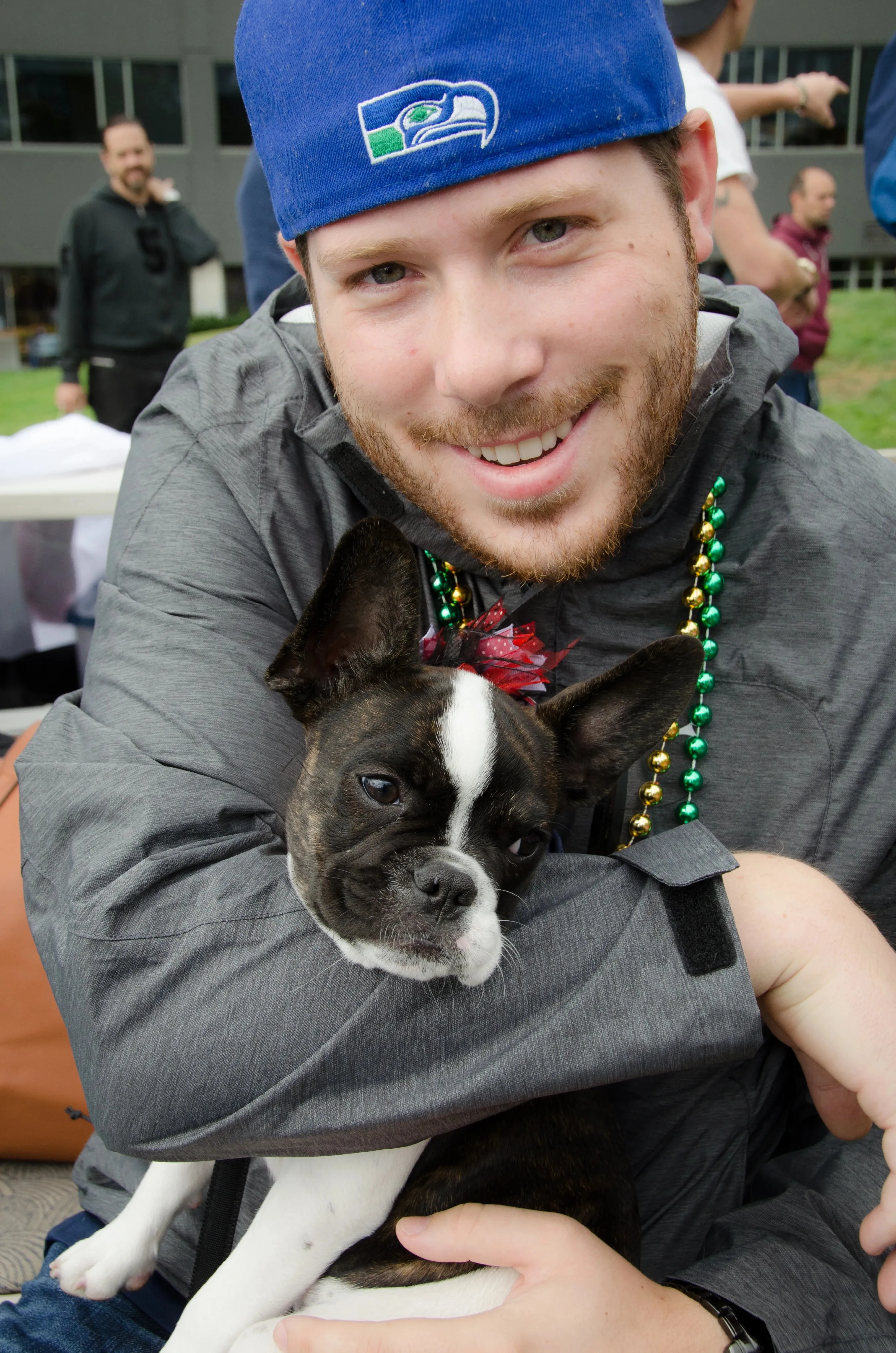 Man cuddling a Royal Frenchel puppy close to his chest.