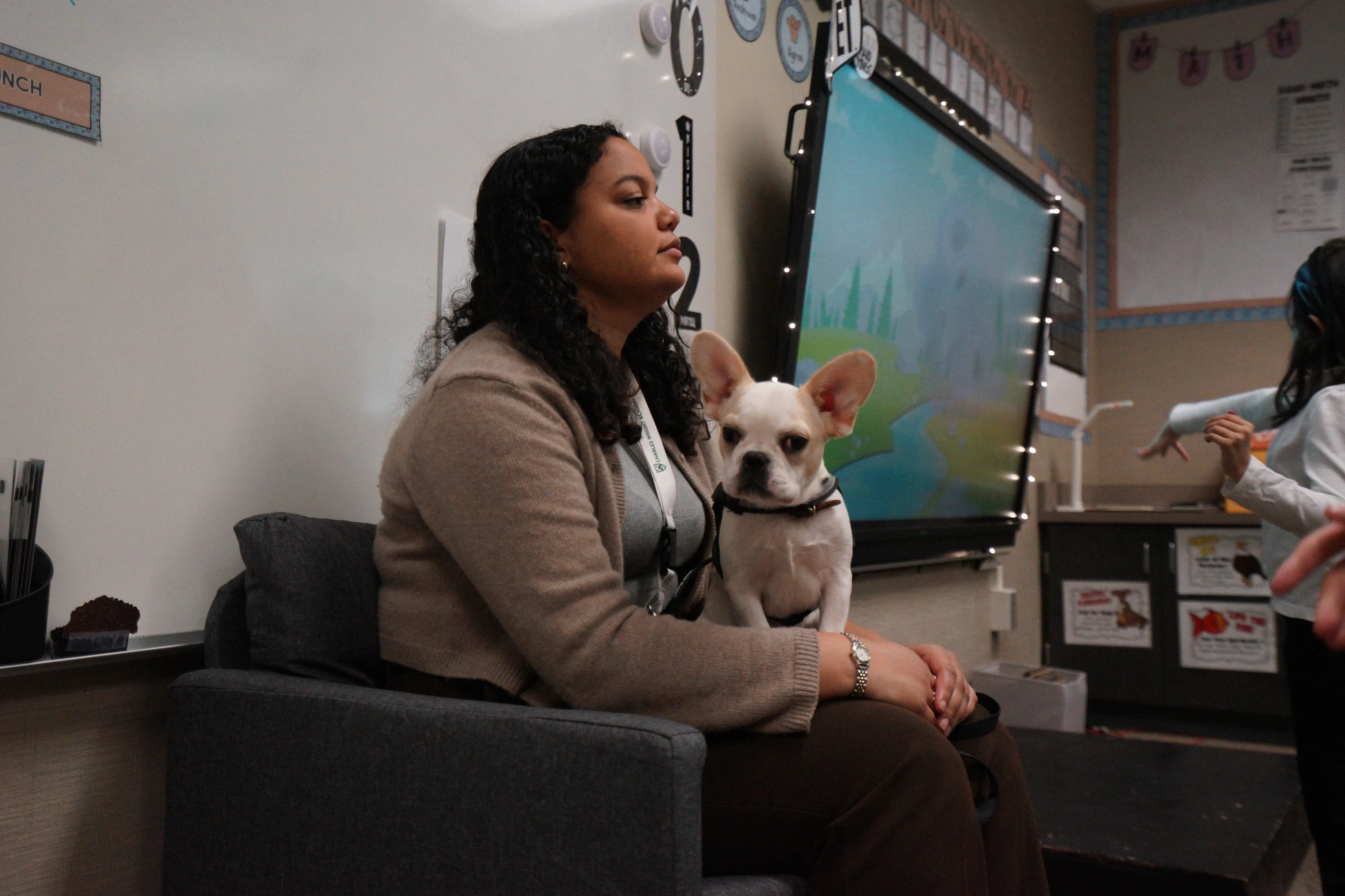 Royal Frenchel sitting beside a woman in a classroom.