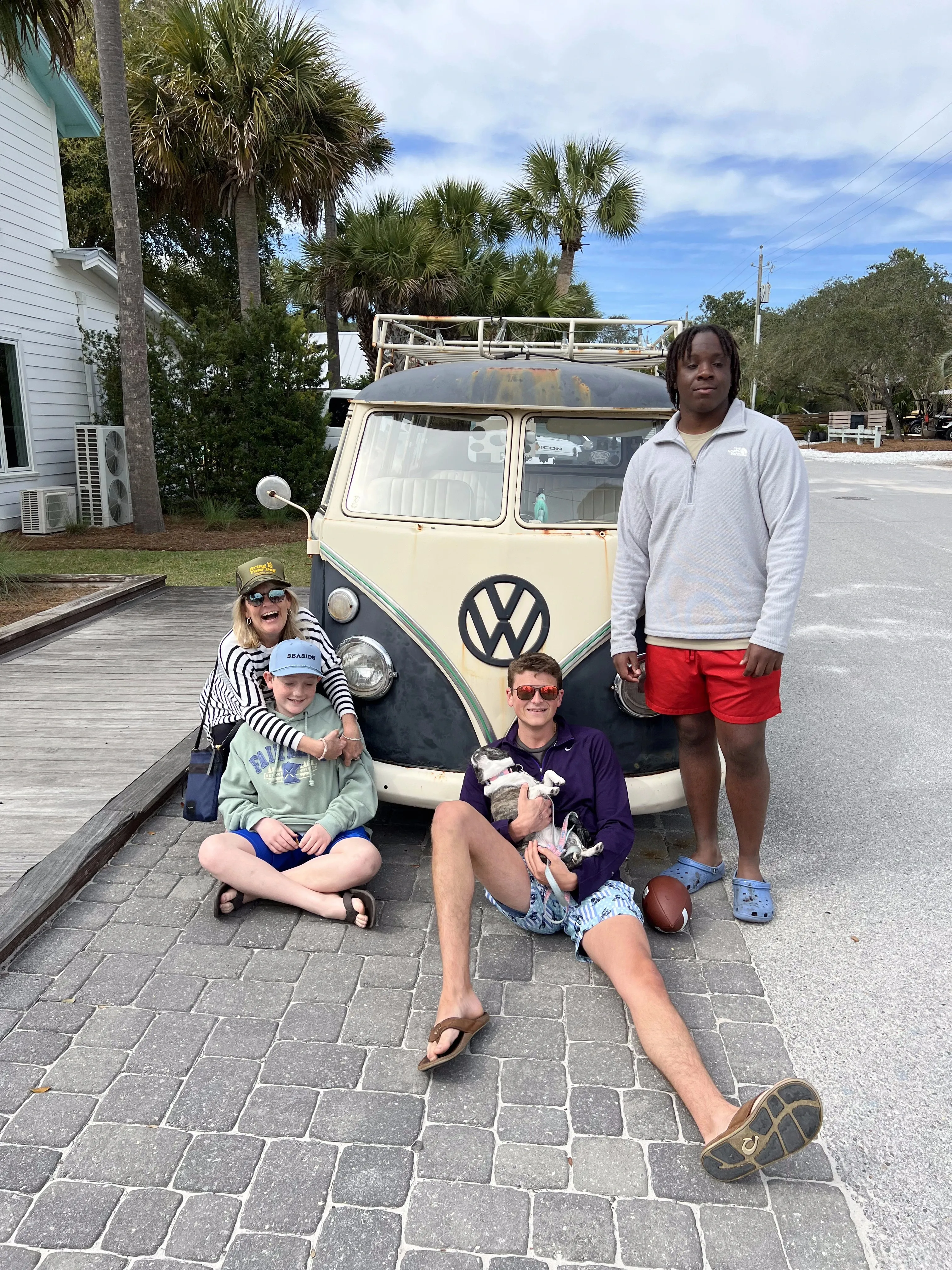 Family posing outdoors with Royal Frenchels near a van.
