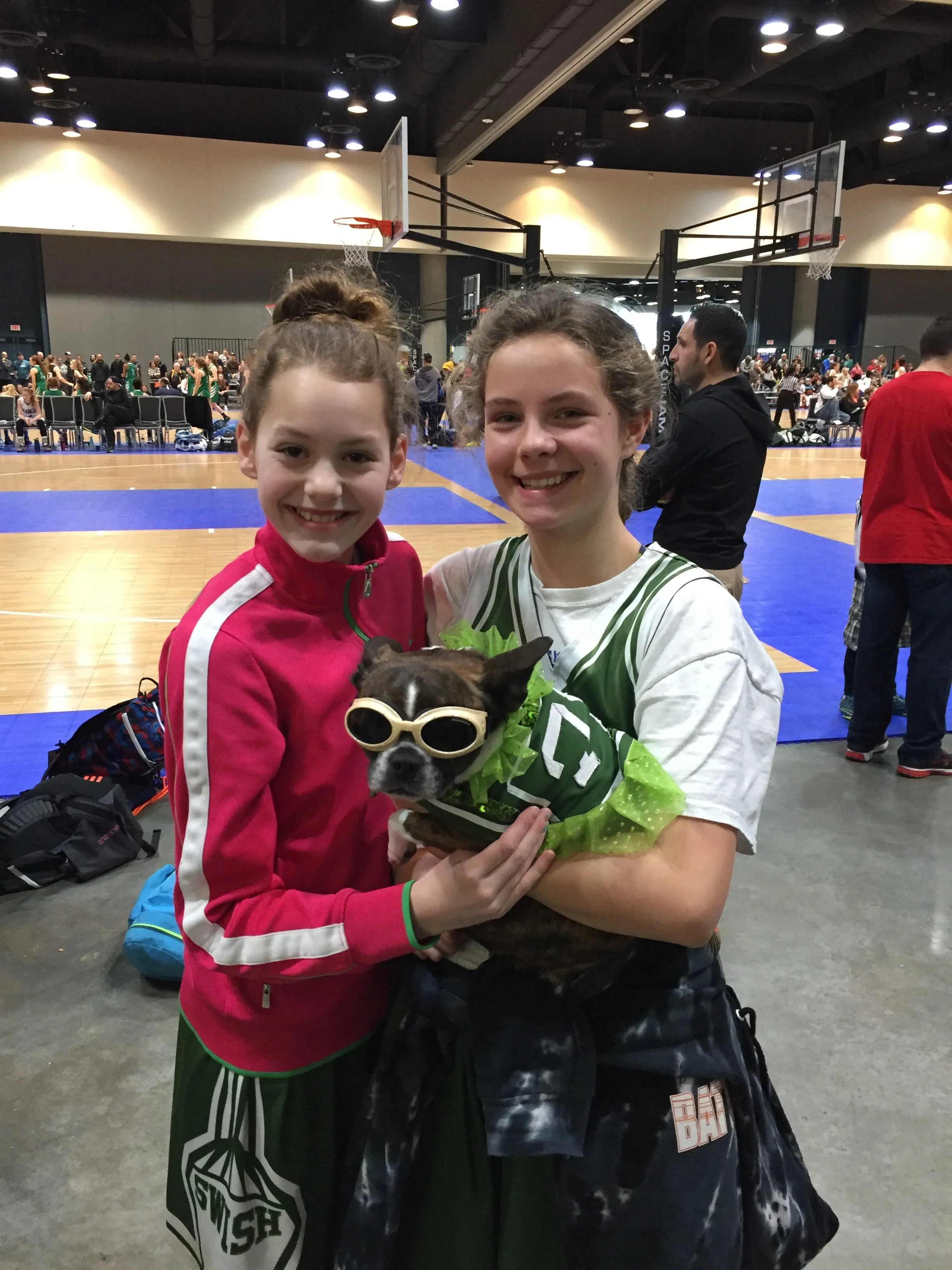 Two girls holding a Royal Frenchel at an indoor event.