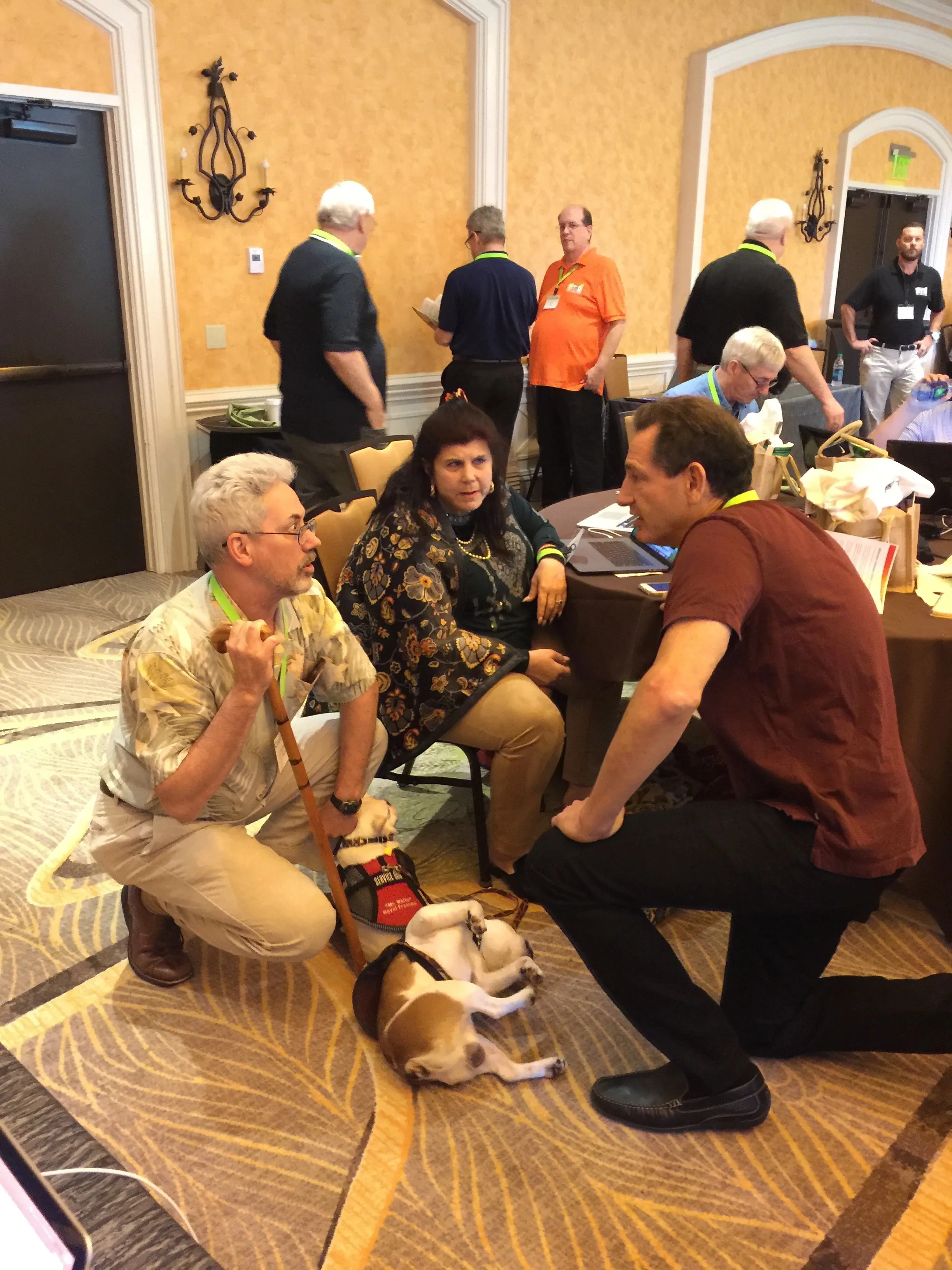 Group gathered around a Royal Frenchel during an indoor meeting.