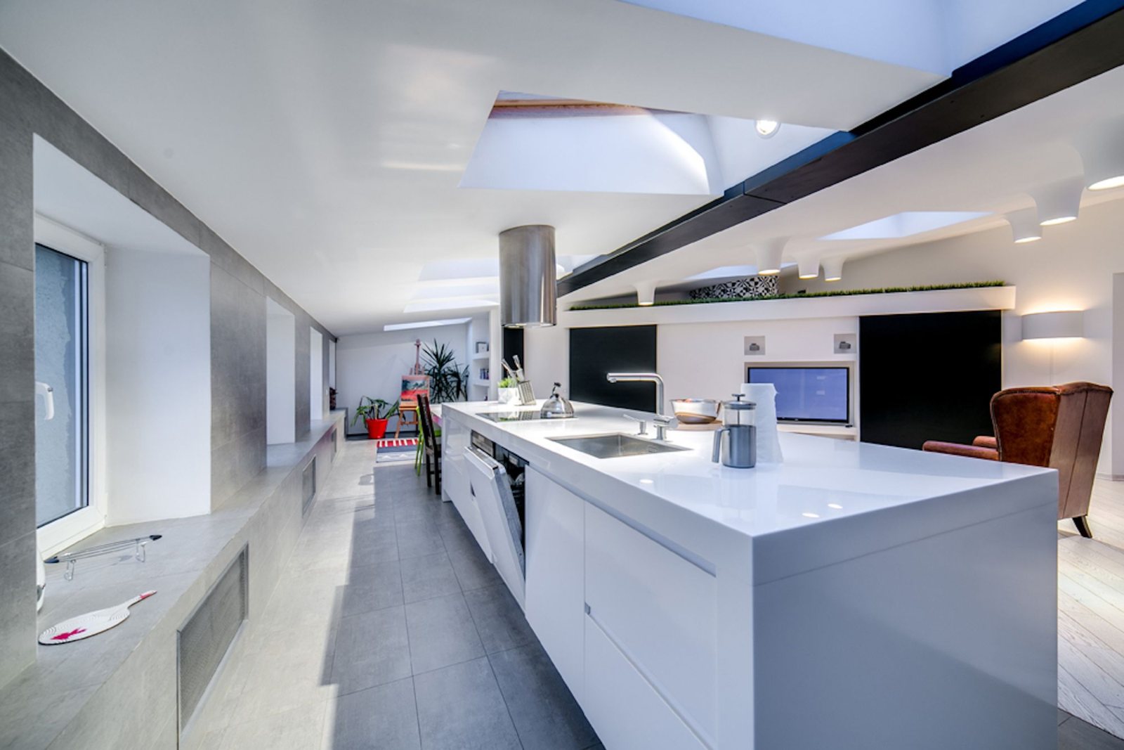 Cuisine moderne sous verrière de toit, îlot blanc — pose de Velux à Chantepie par Avenir Eco Couverture