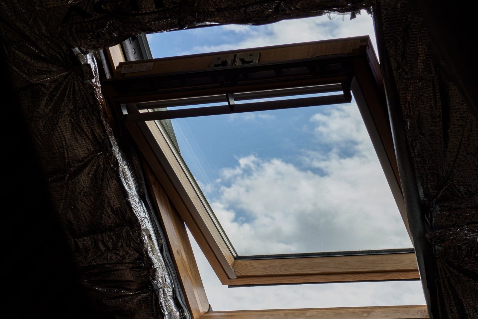 Fenêtre de toit ouverte sur le ciel, vue de l’intérieur des combles