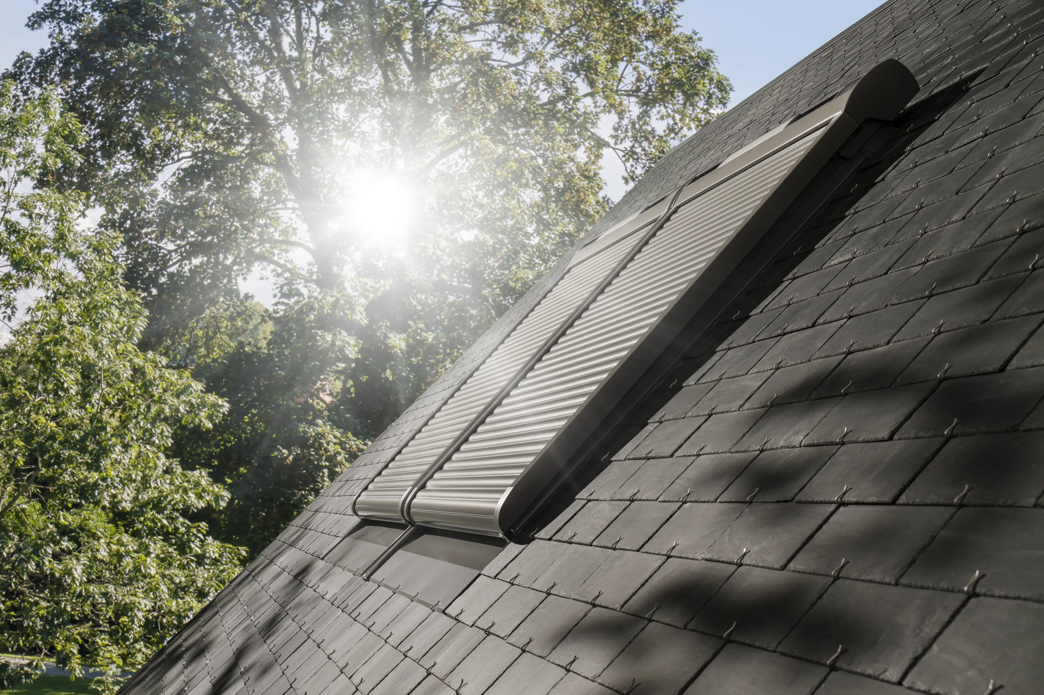 Chambre sous combles occultée par un volet roulant VELUX
