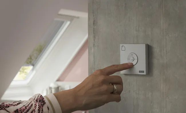 Séjour sous combles ouvert par des fenêtres de toit VELUX équipées de stores extérieurs