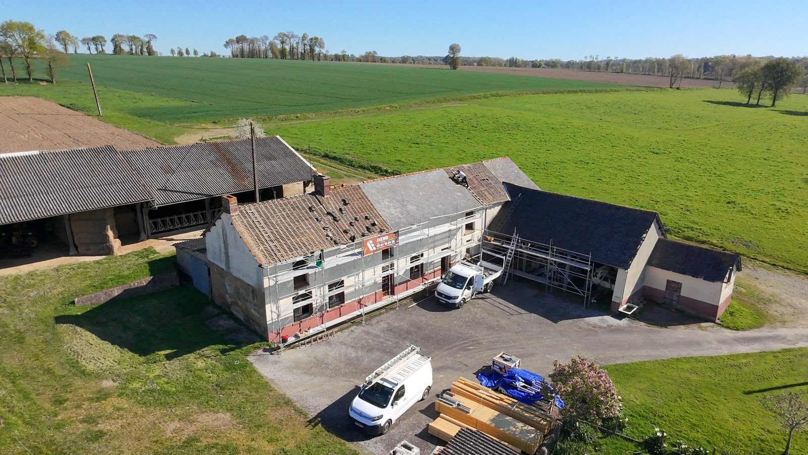 Le corps de ferme en L au milieu des champs, chantier de couverture en cours — Gévezé