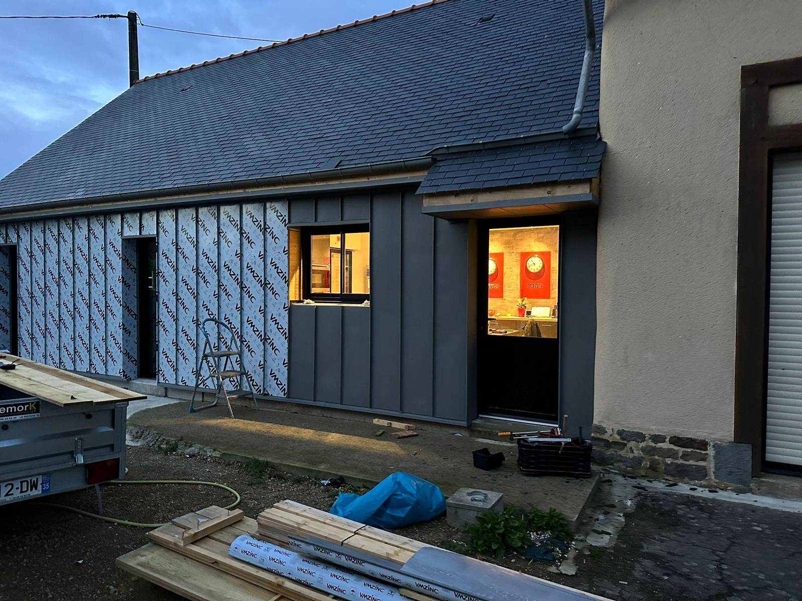 Pose du bardage zinc quartz à joint debout sur la façade, film de protection encore en place à La Mézière