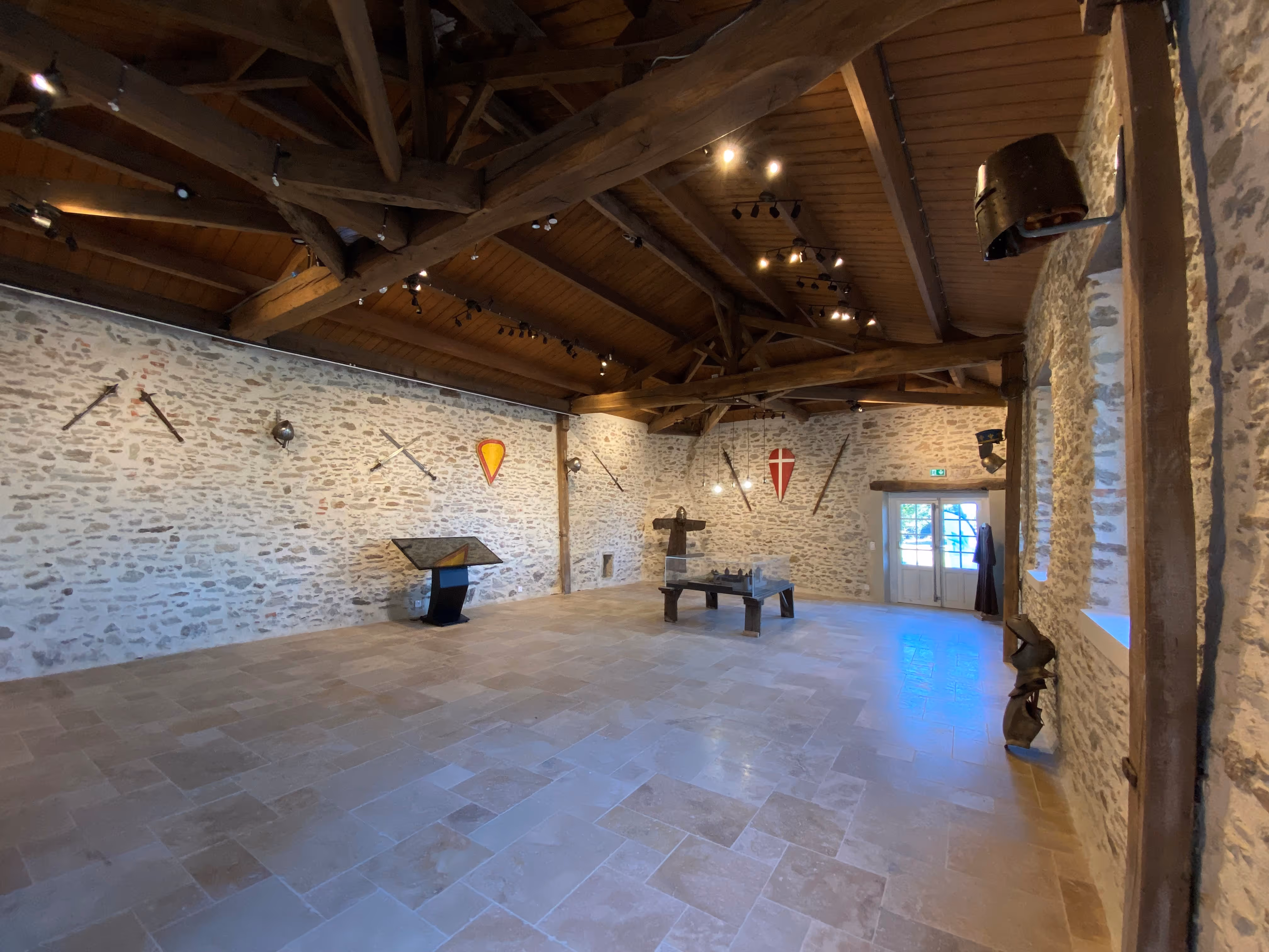 Tours médiévales en pierre dans un jardin avec une maison et un ciel partiellement nuageux.