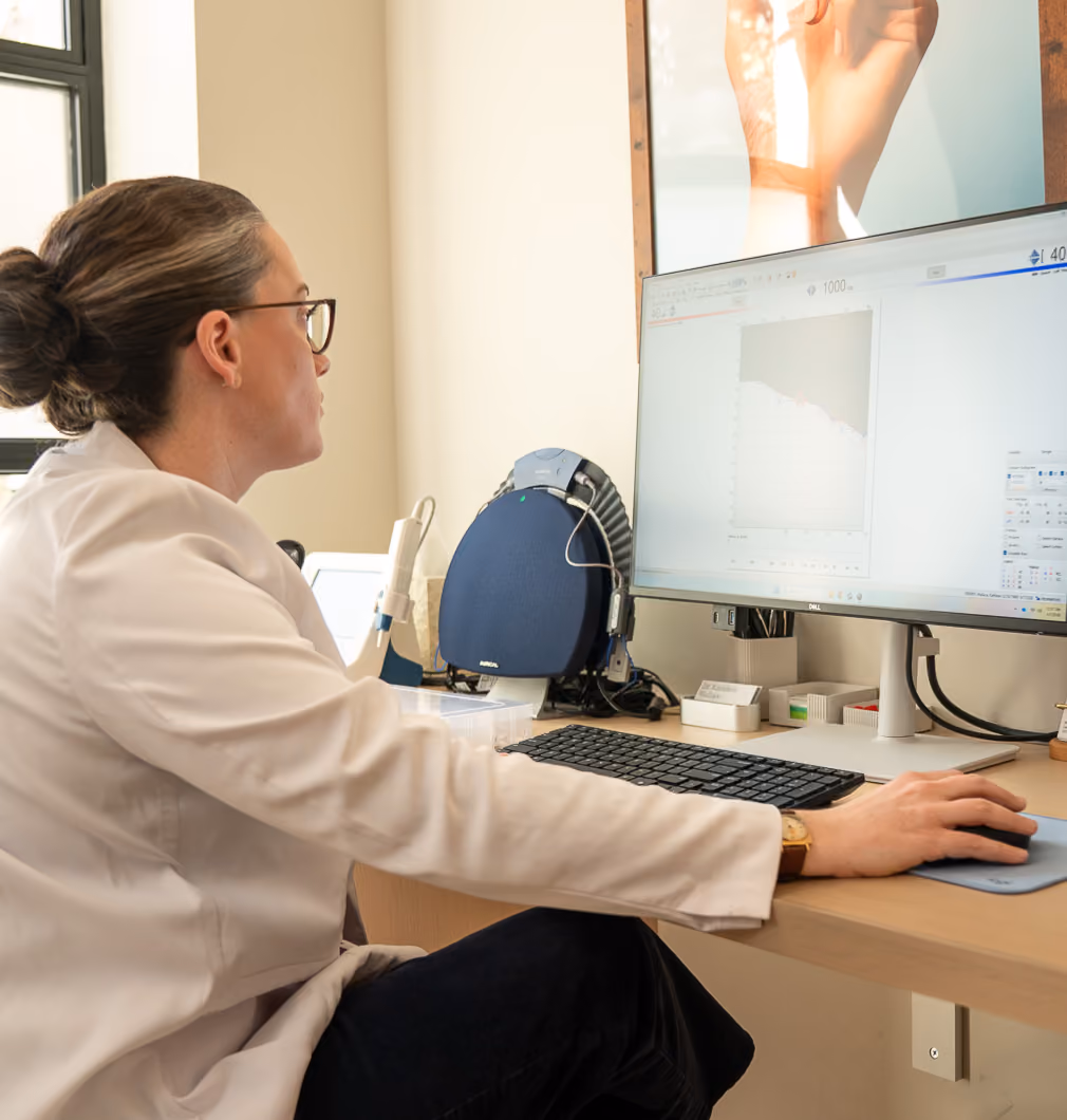Fortell audiologist reviewing a patient's hearing data on a computer.